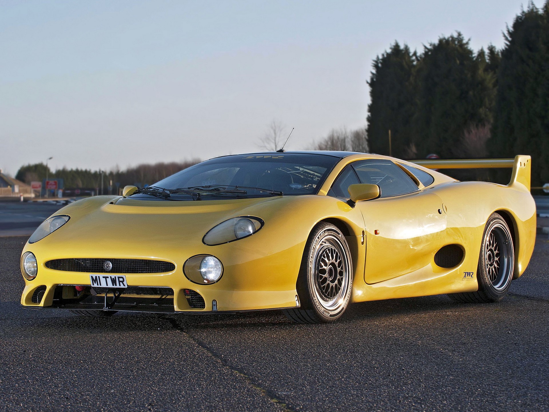 Yellow Jaguar XJ220 race car on asphalt HD Wallpaper