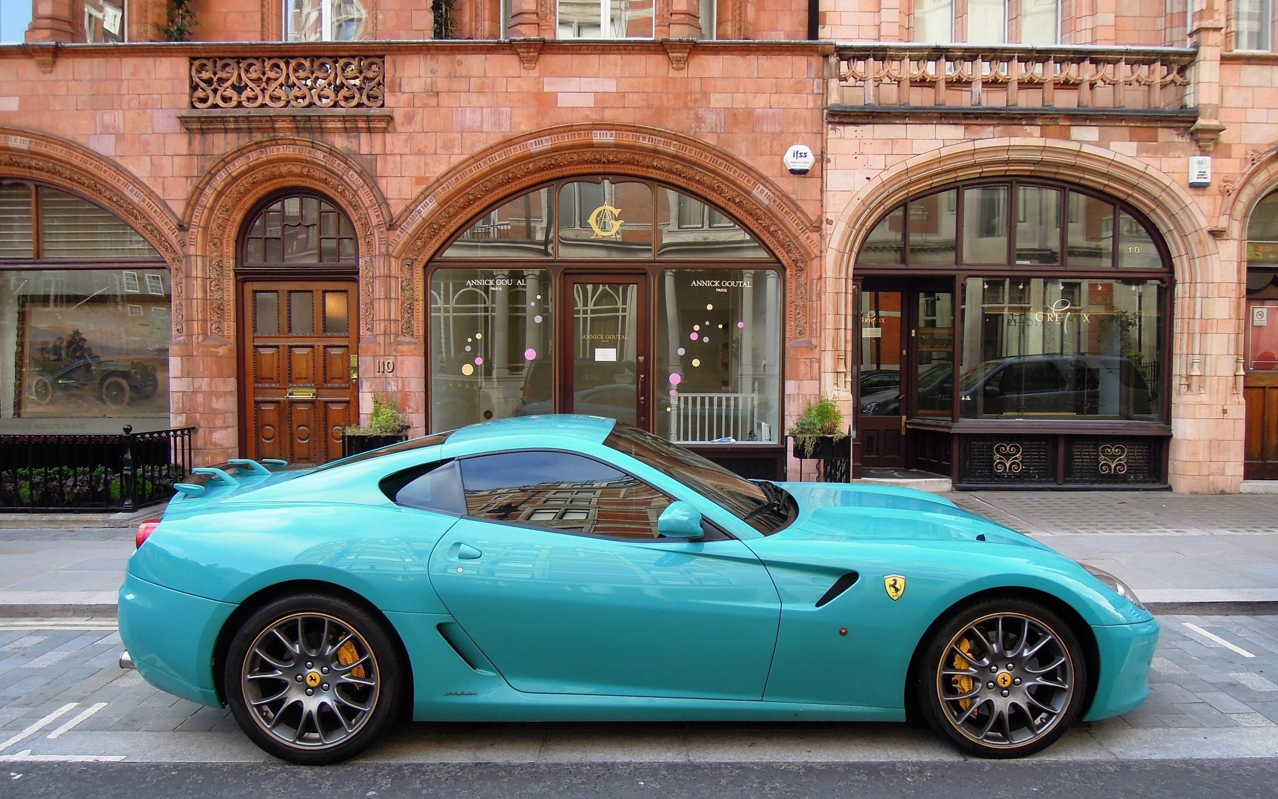 Turquoise Ferrari parked in front of a building HD Wallpaper