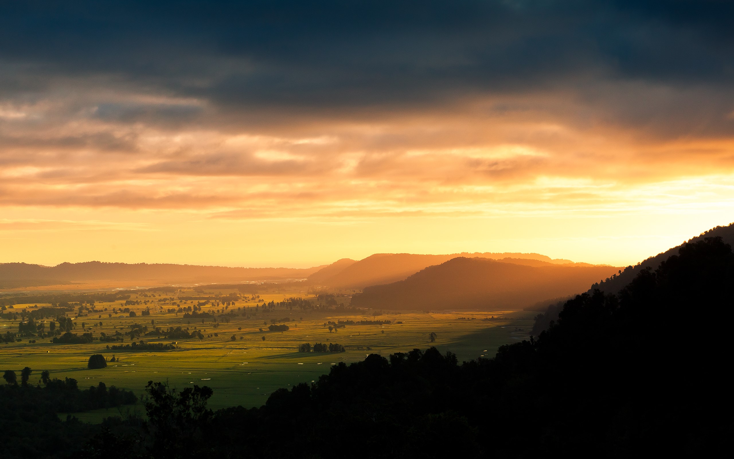 Sunset over a valley with mountains and clouds HD Wallpaper