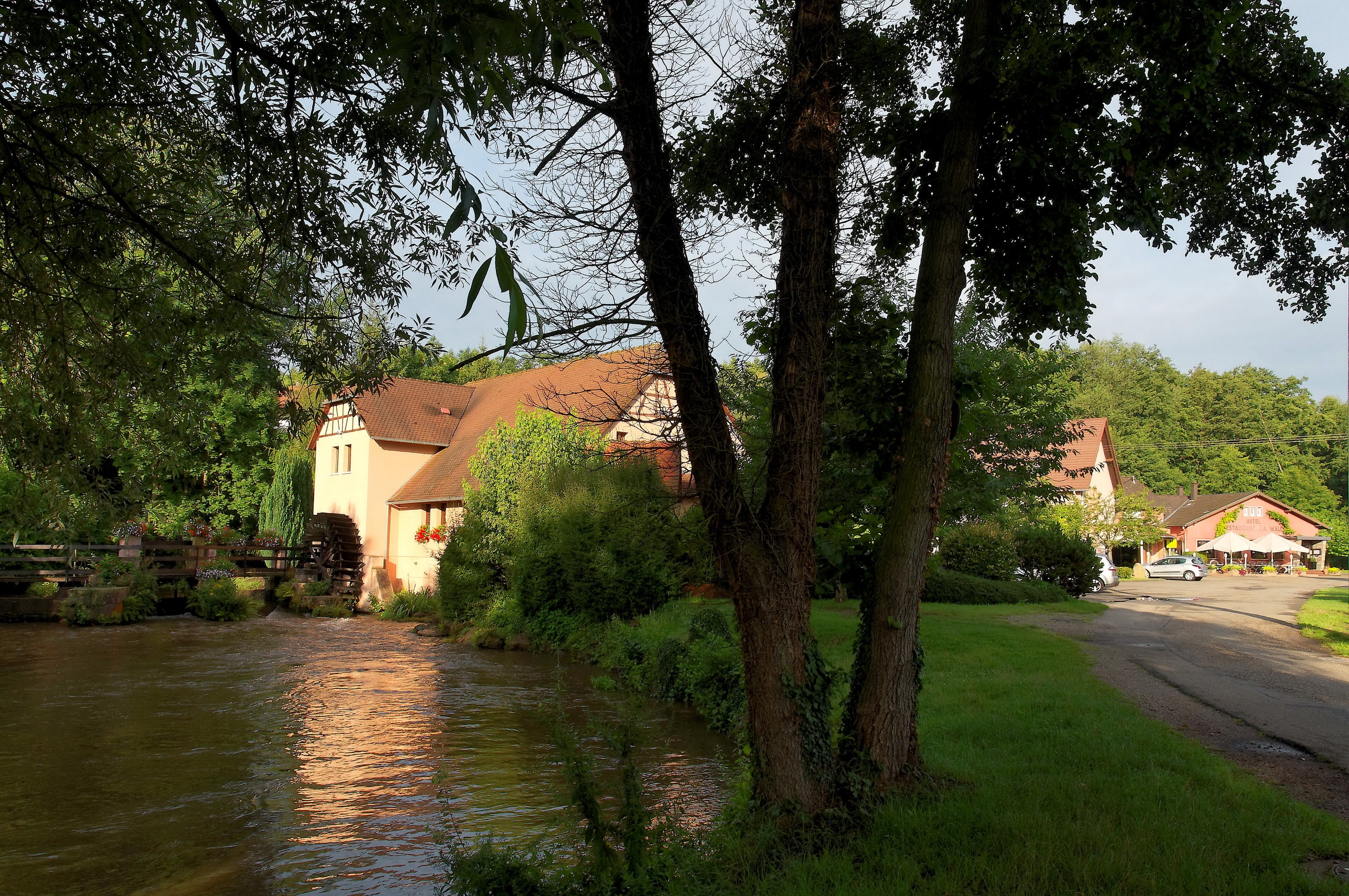 Old mill building with water wheel on a river HD Wallpaper