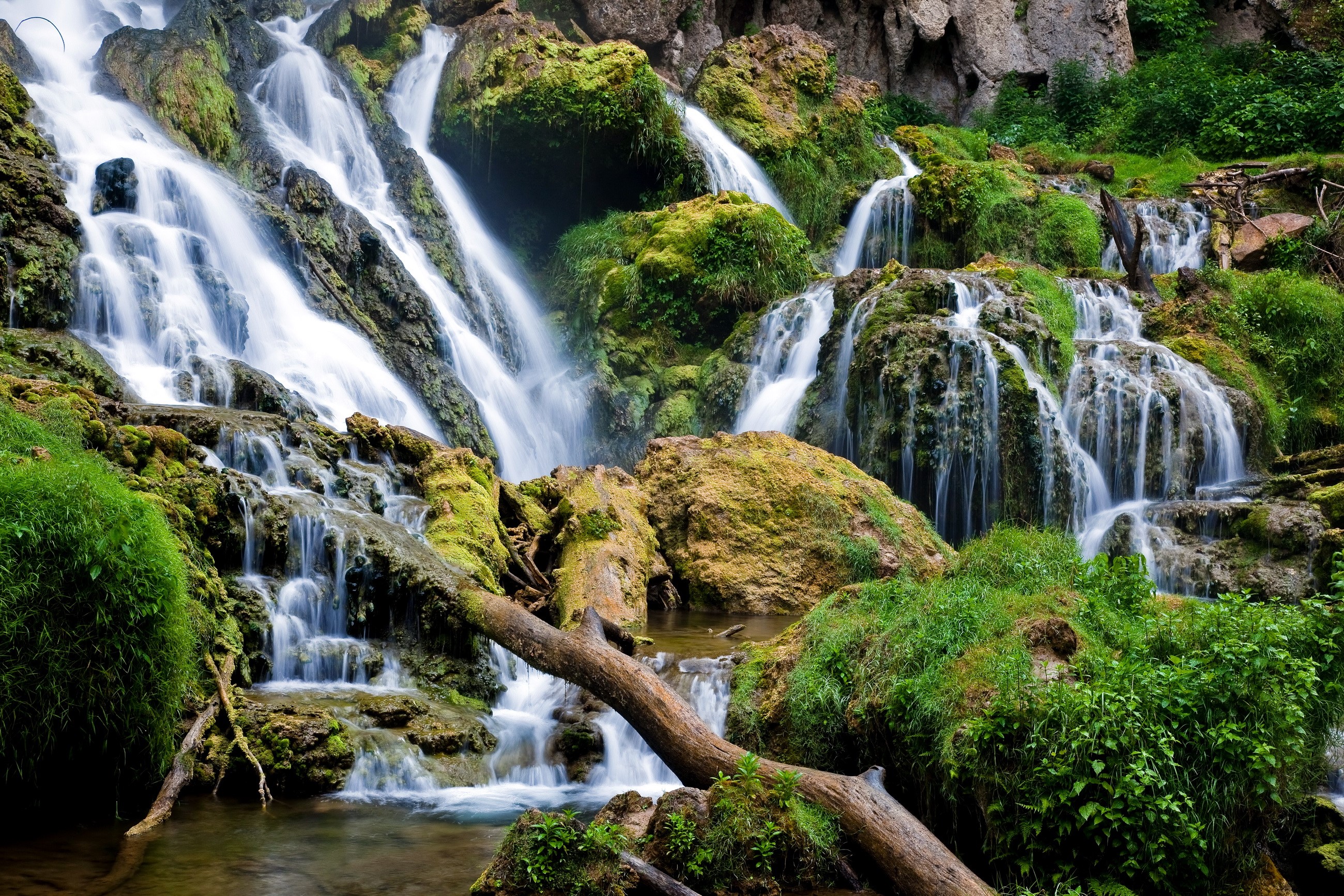 Waterfalls cascading over mossy rocks HD Wallpaper