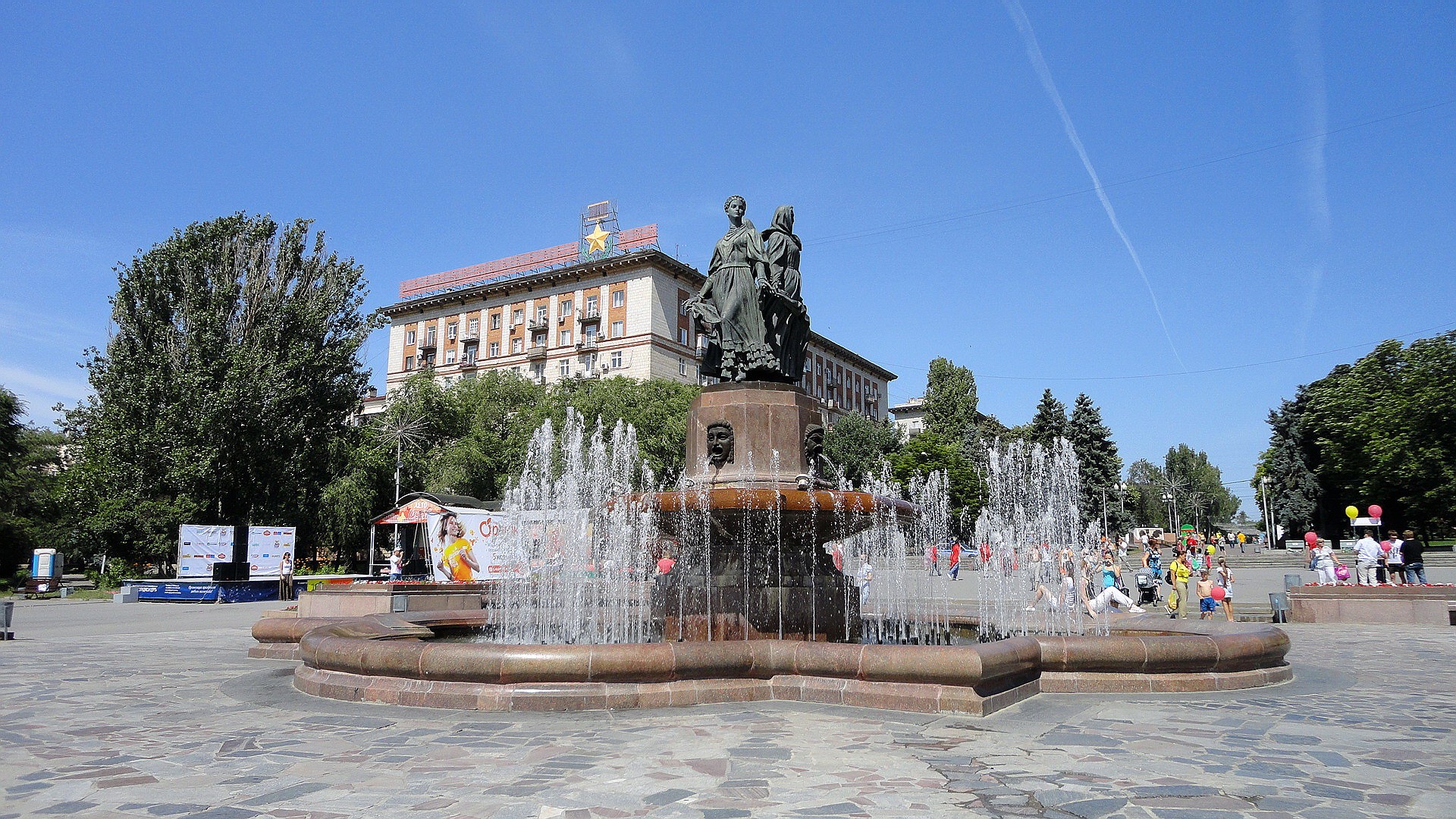 Monumental fountain in a city square with a building HD Wallpaper