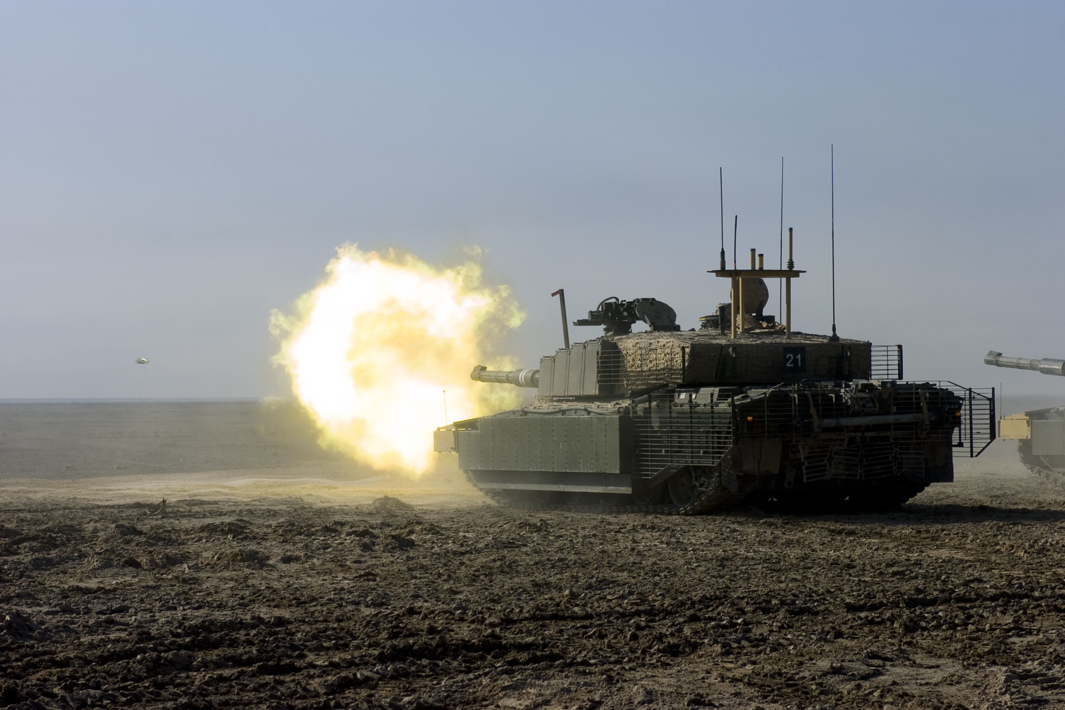 Tank firing a projectile in a barren landscape HD Wallpaper