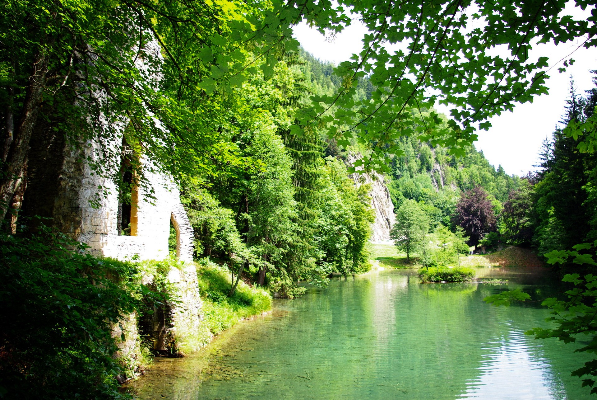 Ruins by a clear lake in a lush green forest HD Wallpaper