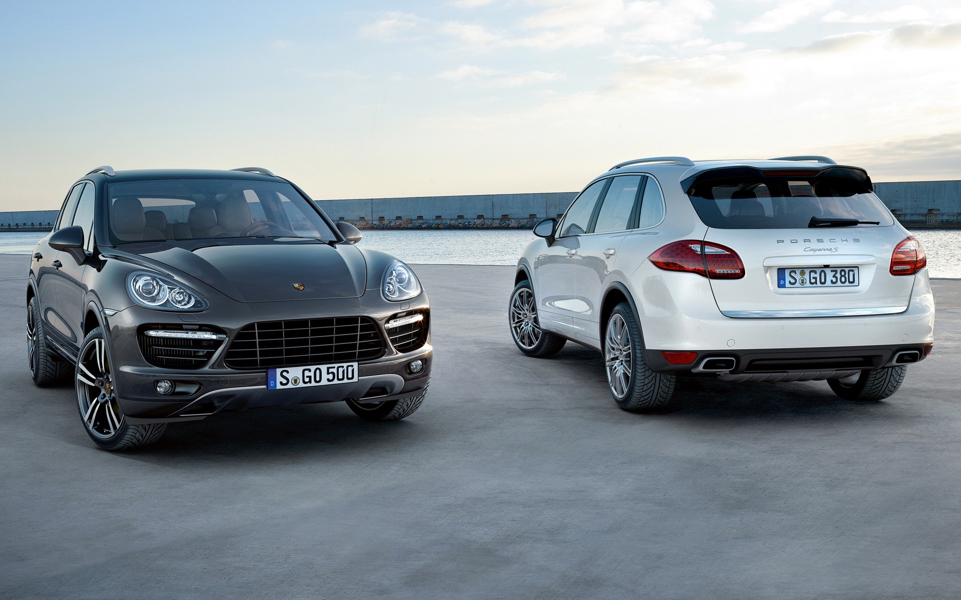 Two Porsche Cayenne SUVs parked outdoors HD Wallpaper
