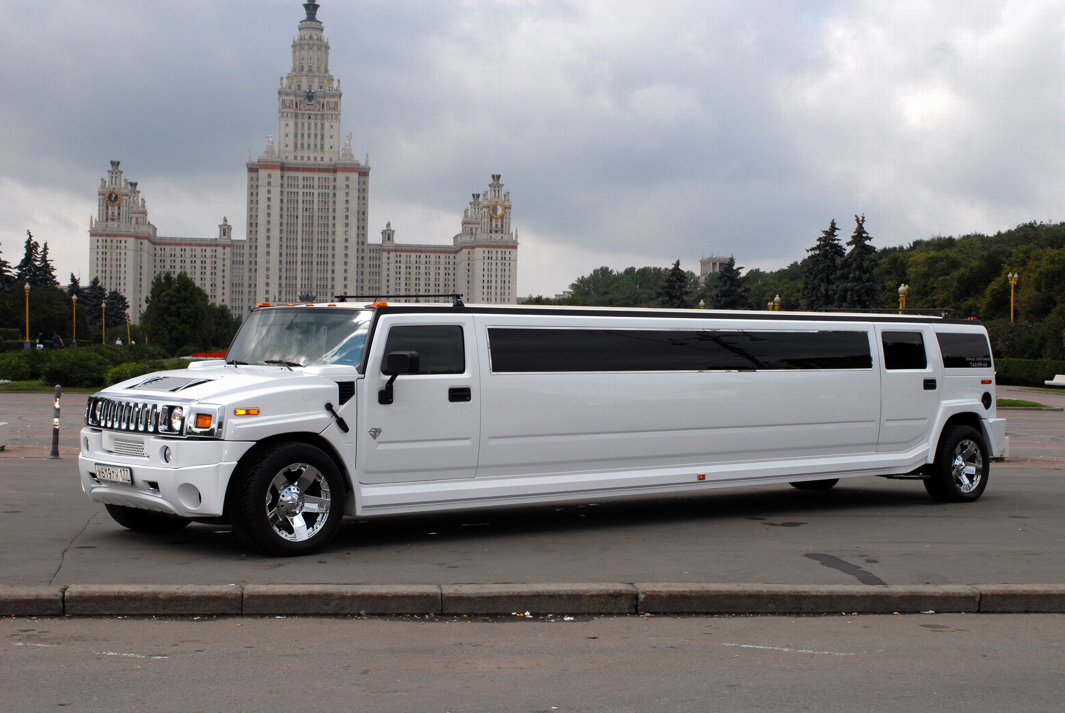 White Hummer H2 Stretch Limousine in front of a large building HD Wallpaper