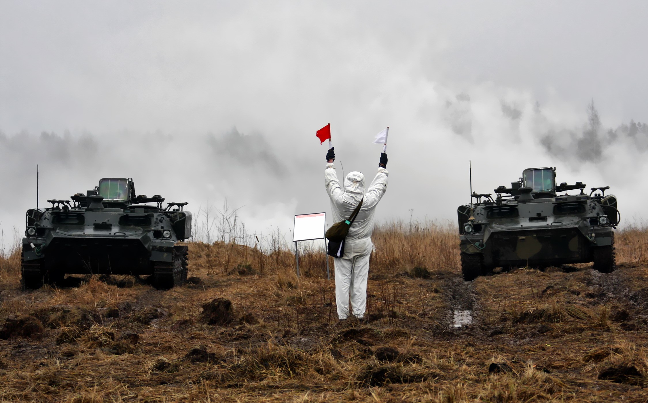 Military personnel directing armored vehicles with flags HD Wallpaper