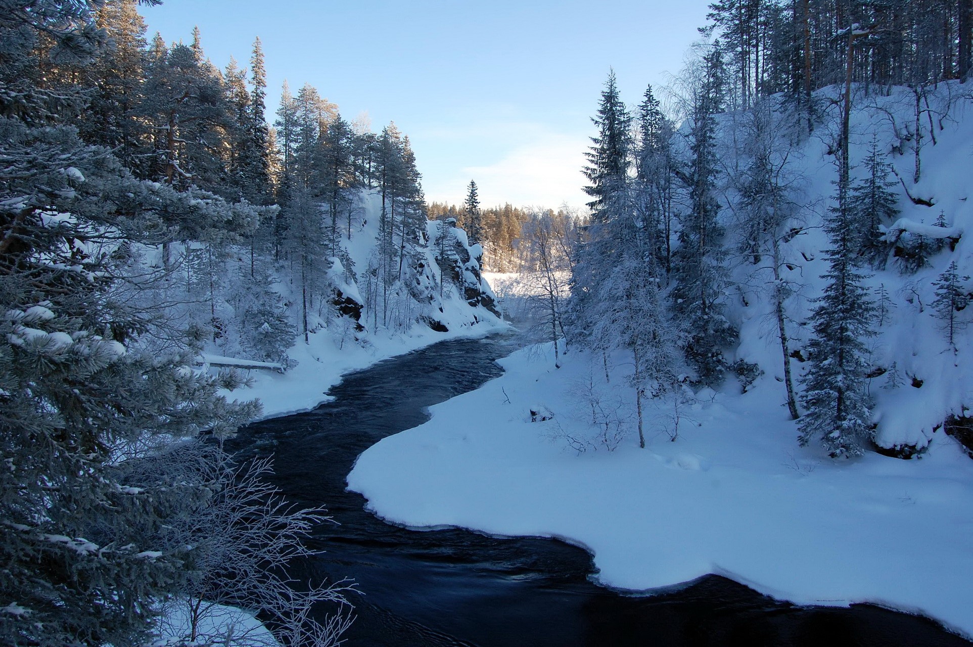 Winter river flowing through a snow-covered forest HD Wallpaper