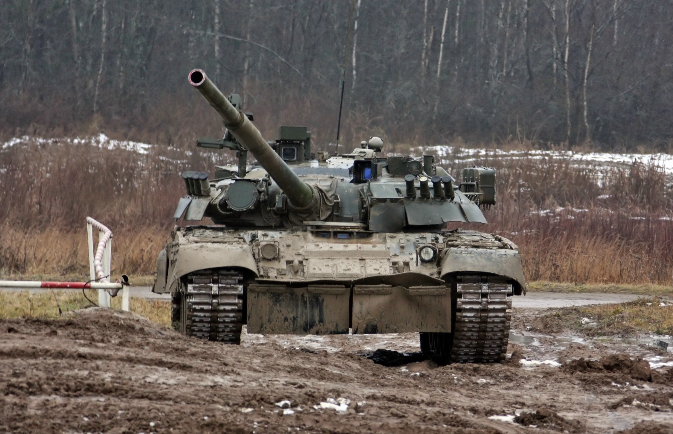 A muddy tank in a wooded area HD Wallpaper