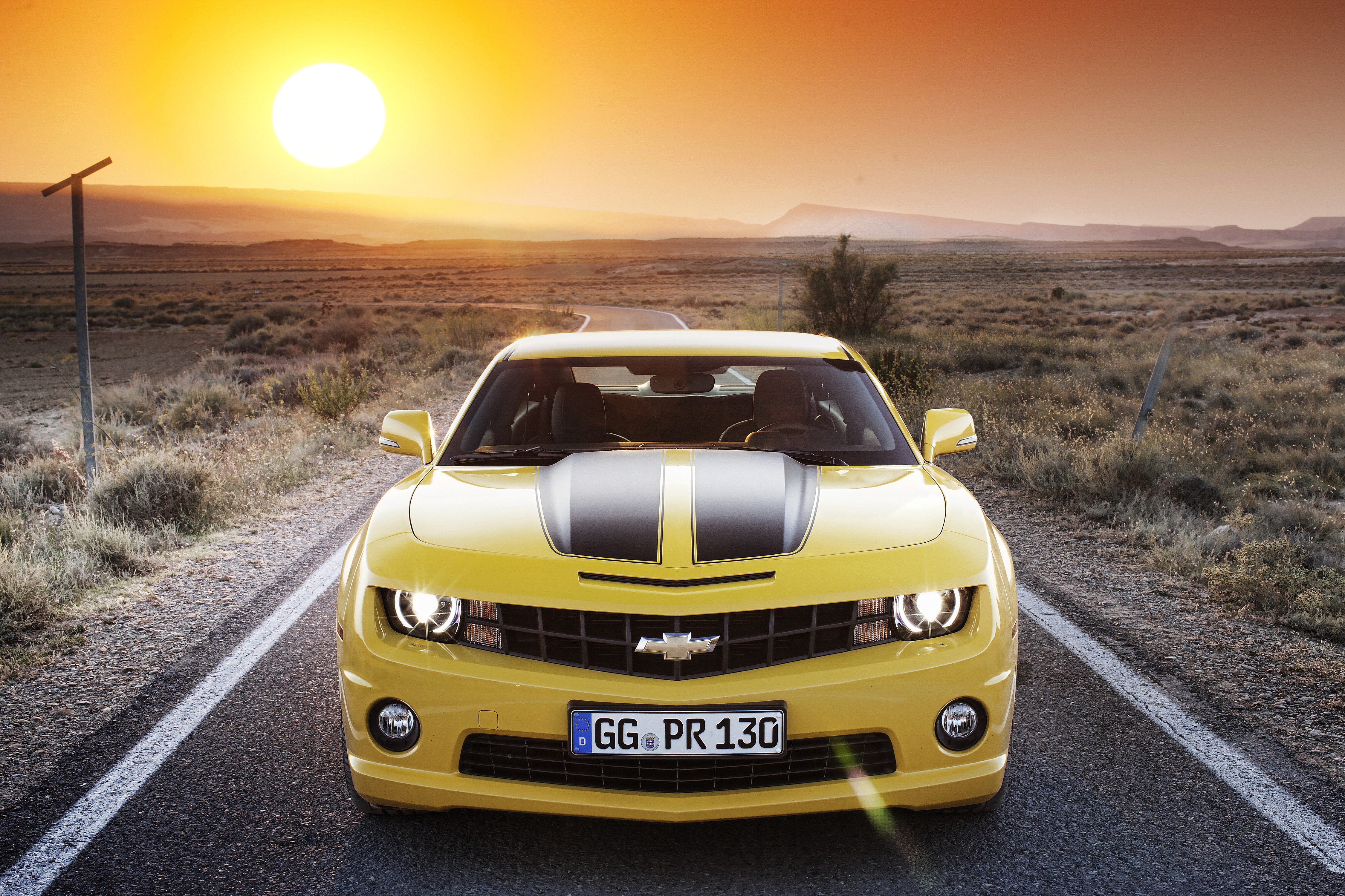 Yellow Chevrolet Camaro on a Desert Road at Sunset HD Wallpaper