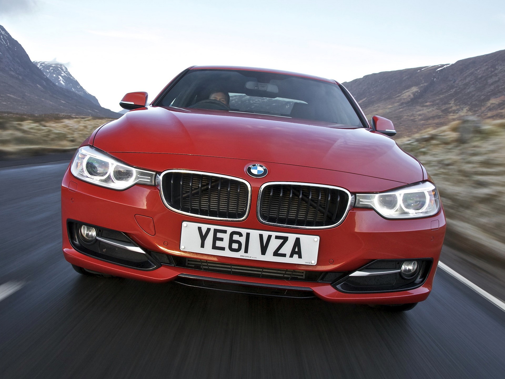 Red BMW driving on a road with mountains HD Wallpaper