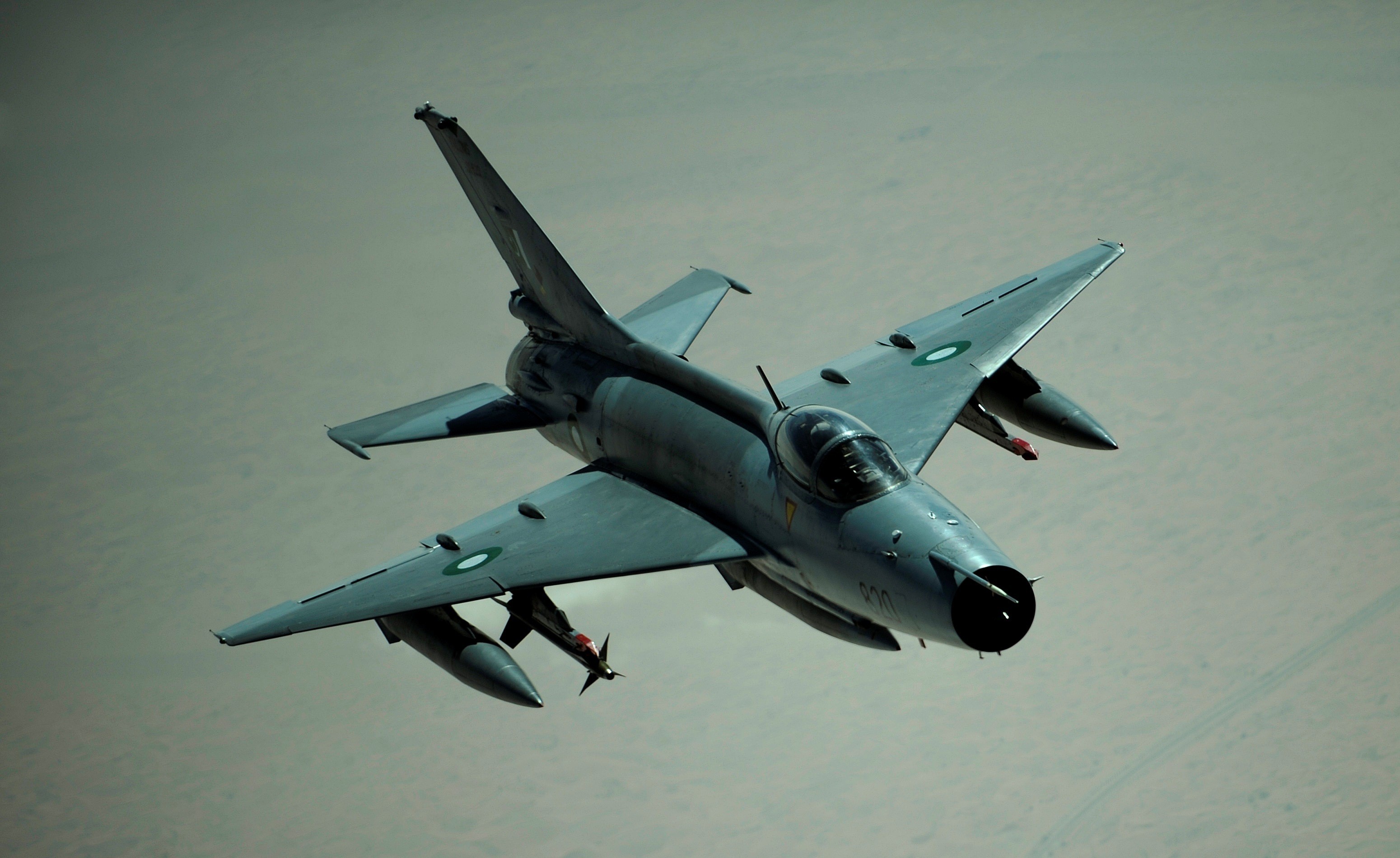 Fighter jet flying over desert landscape HD Wallpaper