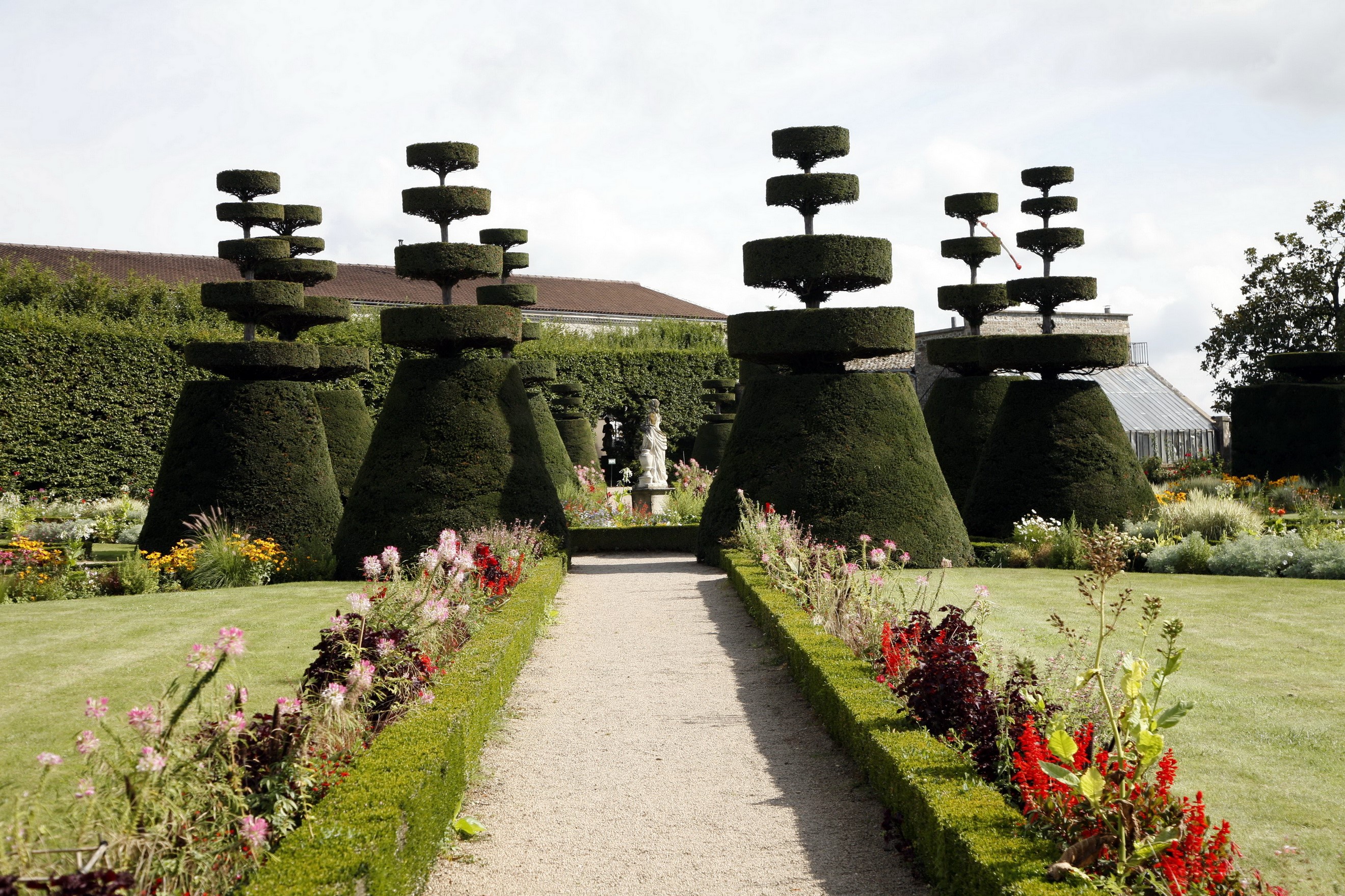 Topiary garden with sculpted bushes and flowers HD Wallpaper