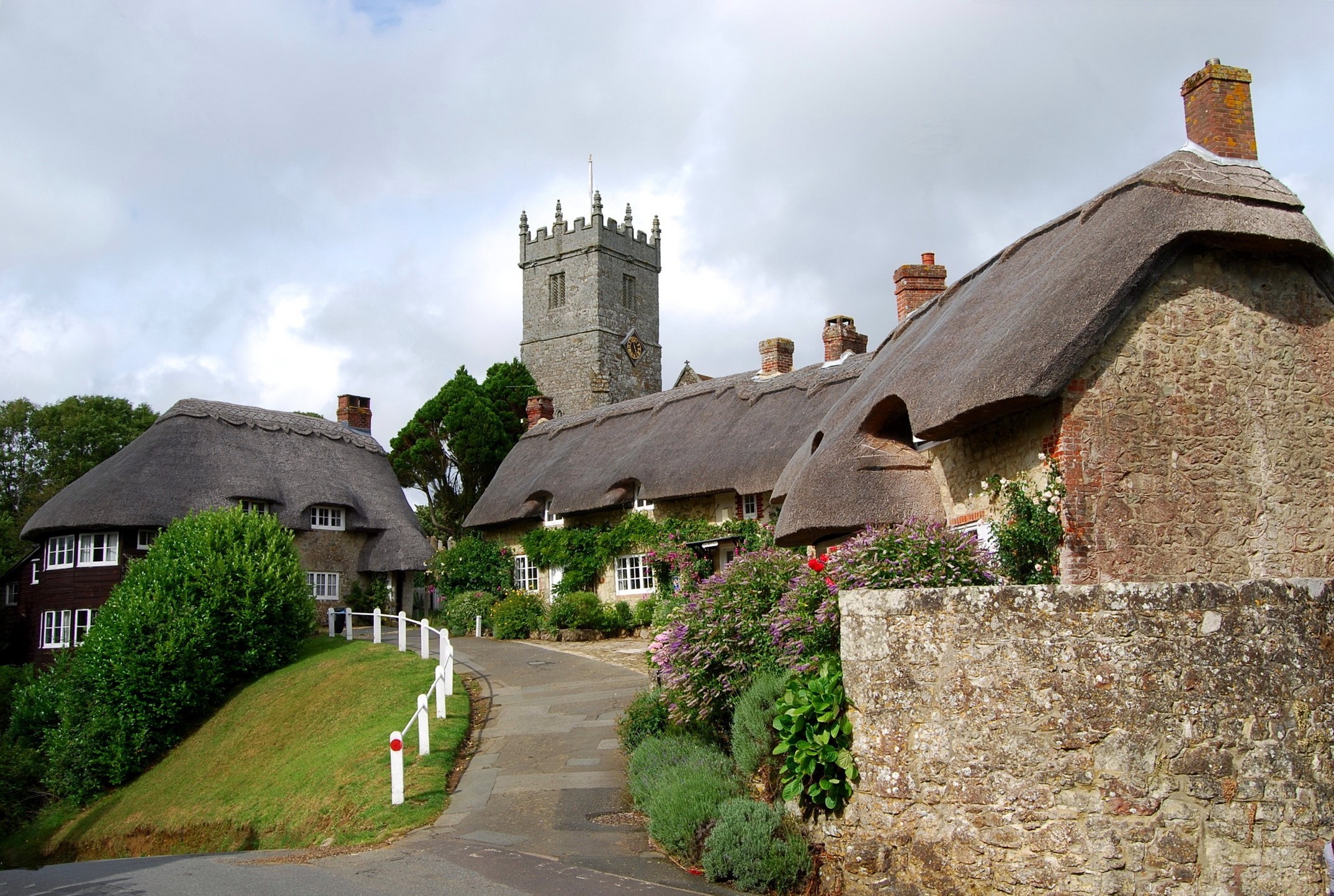 Thatched cottages and church tower in the United Kingdom HD Wallpaper