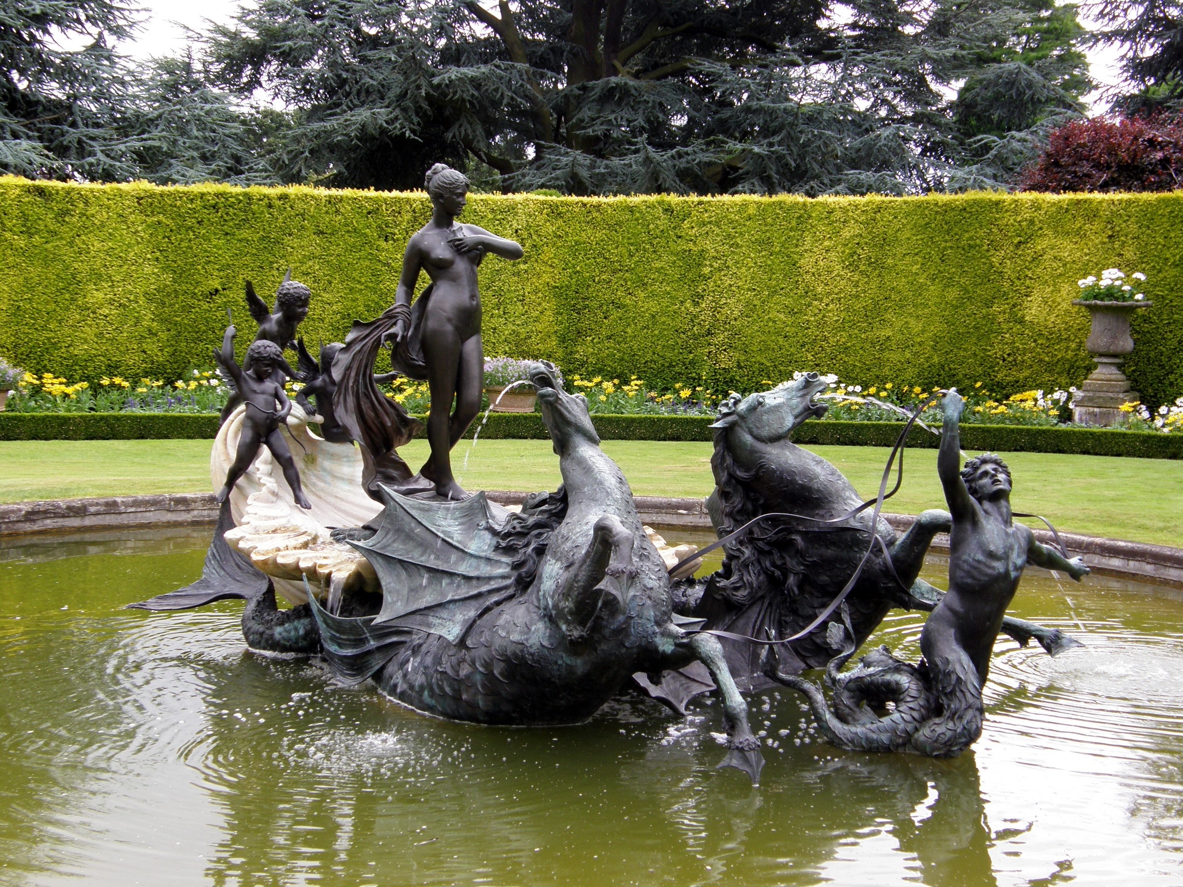 Bronze fountain sculpture of mythological figures in a garden pond HD Wallpaper