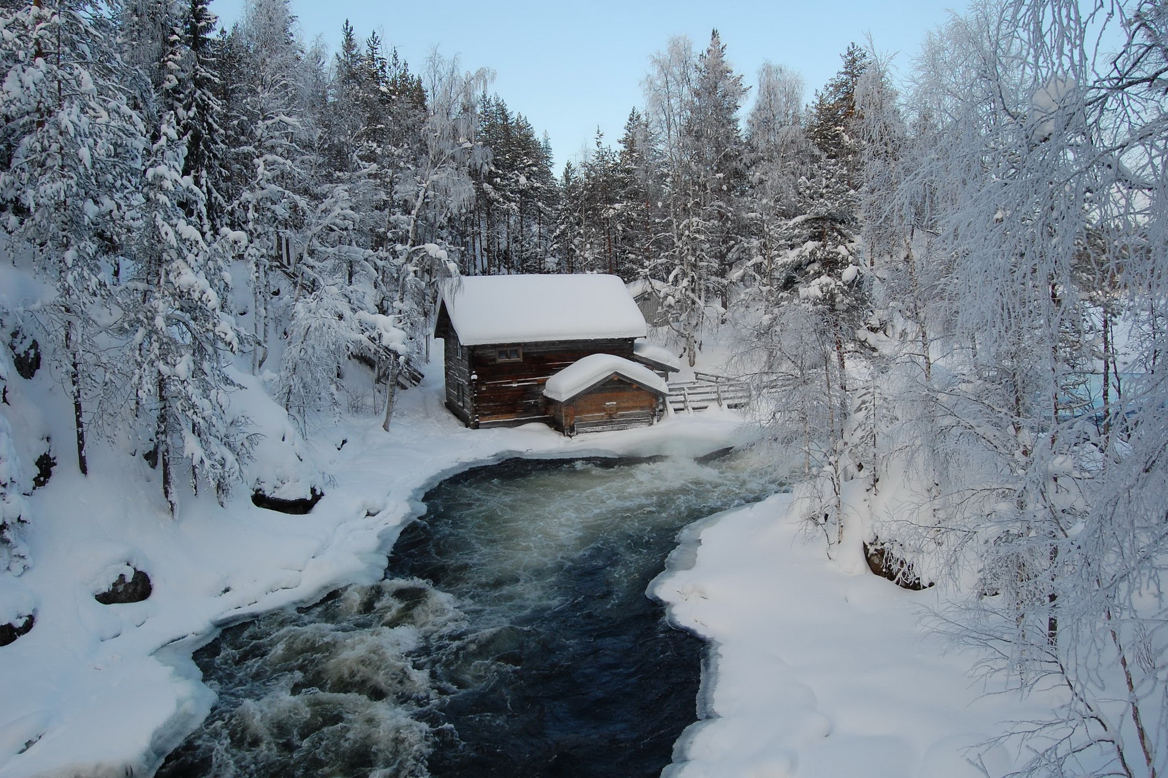 Wooden cabin by a river in a snowy forest HD Wallpaper