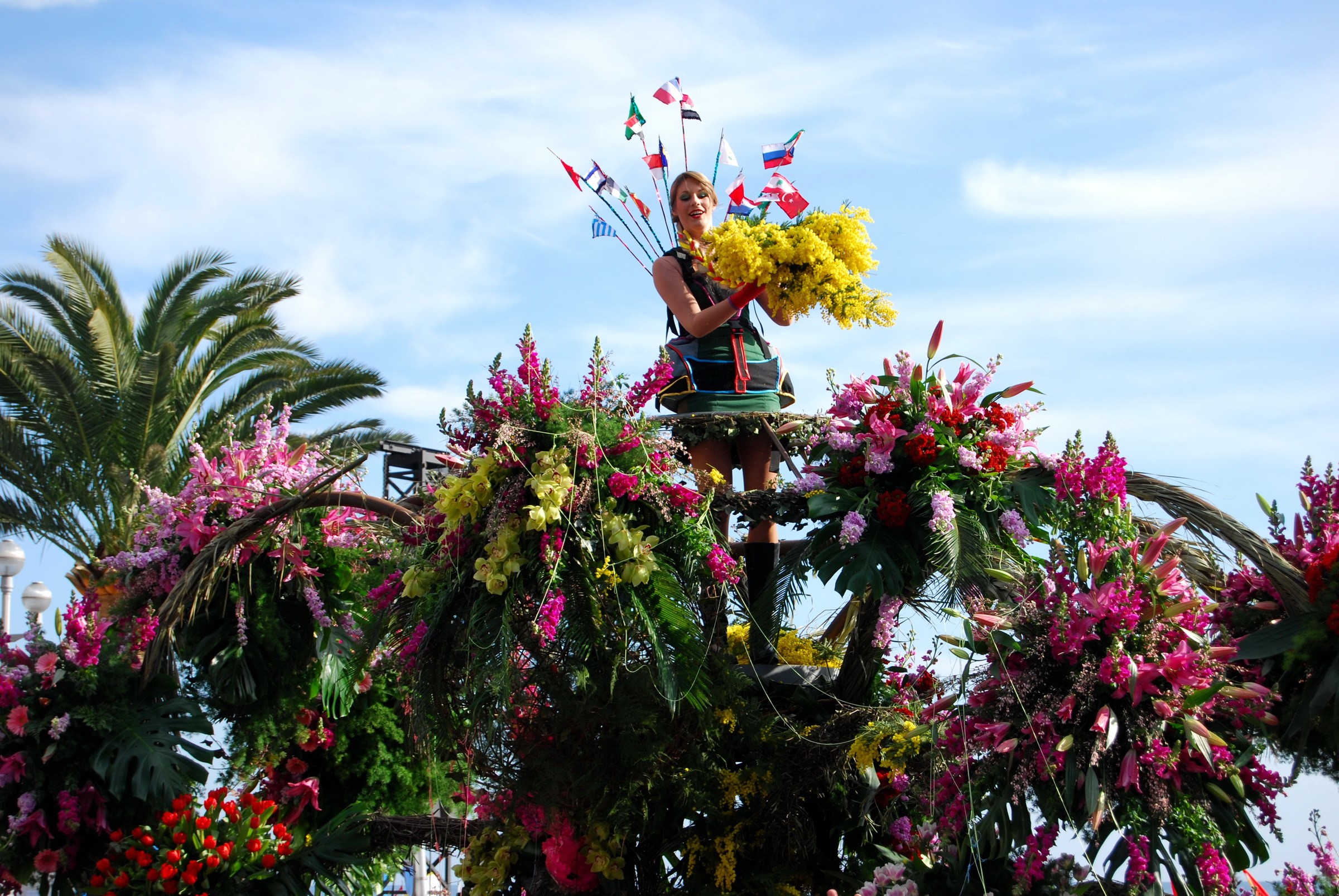 Woman on flower float with flags and flowers HD Wallpaper