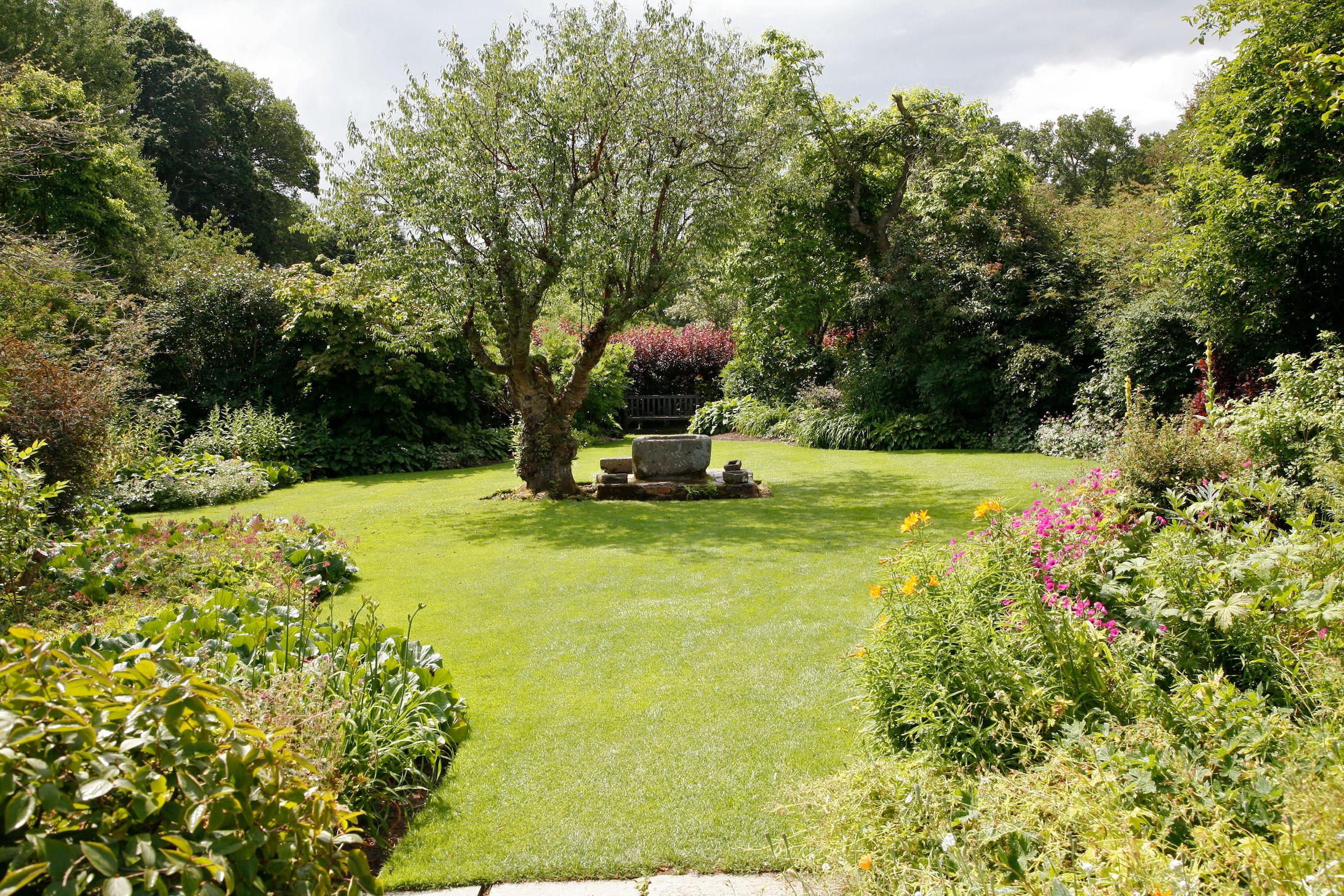 Garden with a stone well and a tree HD Wallpaper