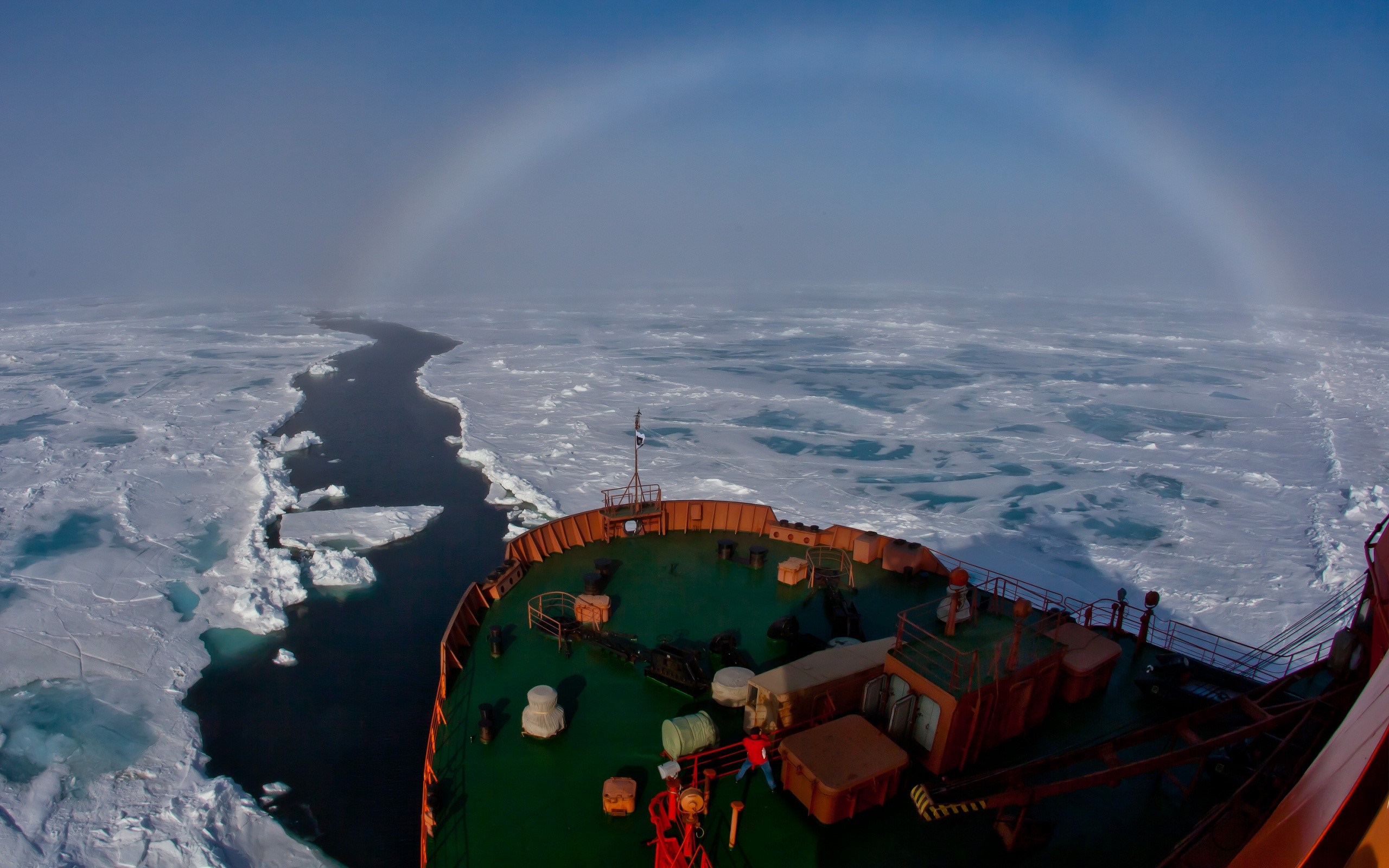 Ship navigating through ice with a sun halo HD Wallpaper