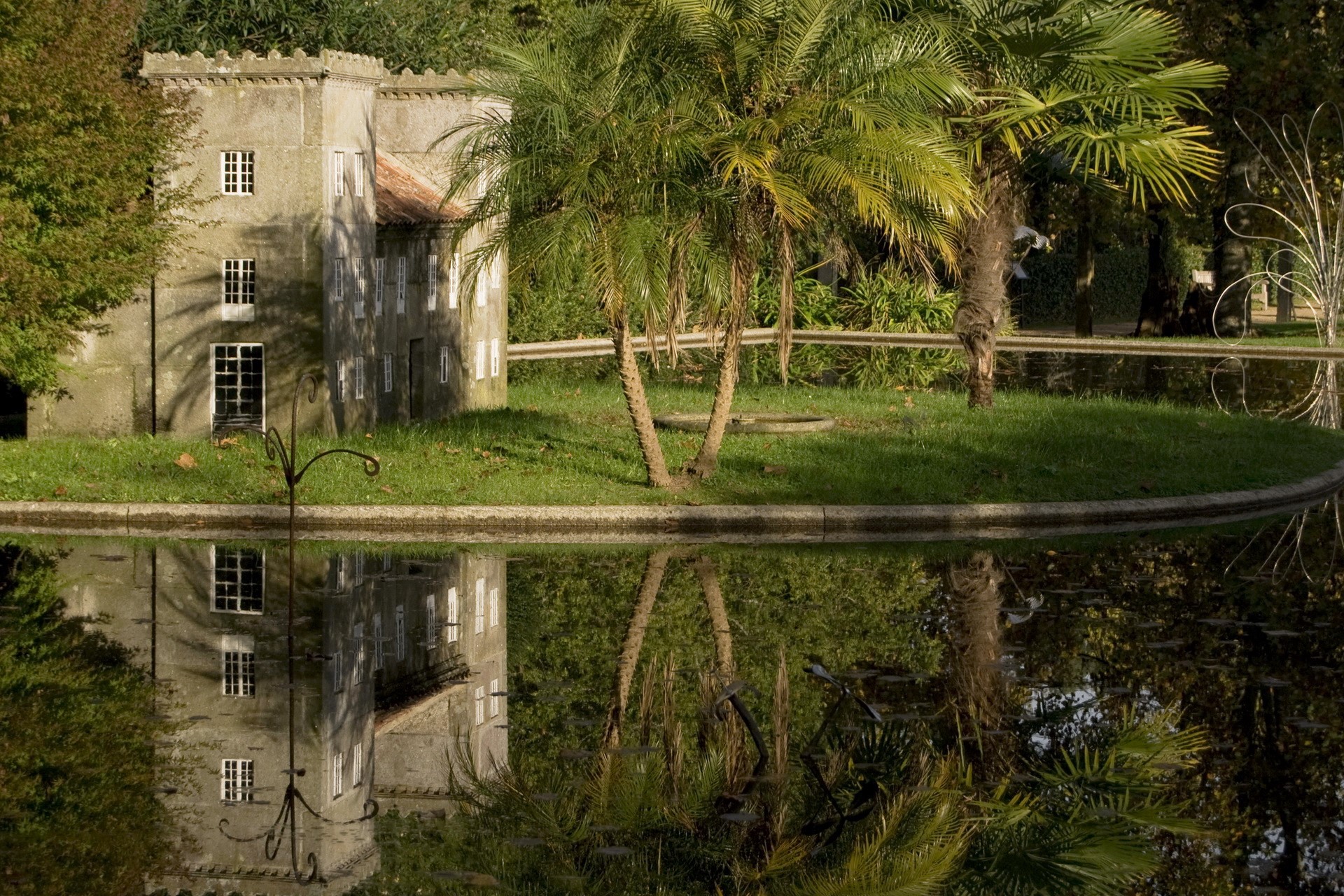 Miniature castle by a pond with palm trees HD Wallpaper