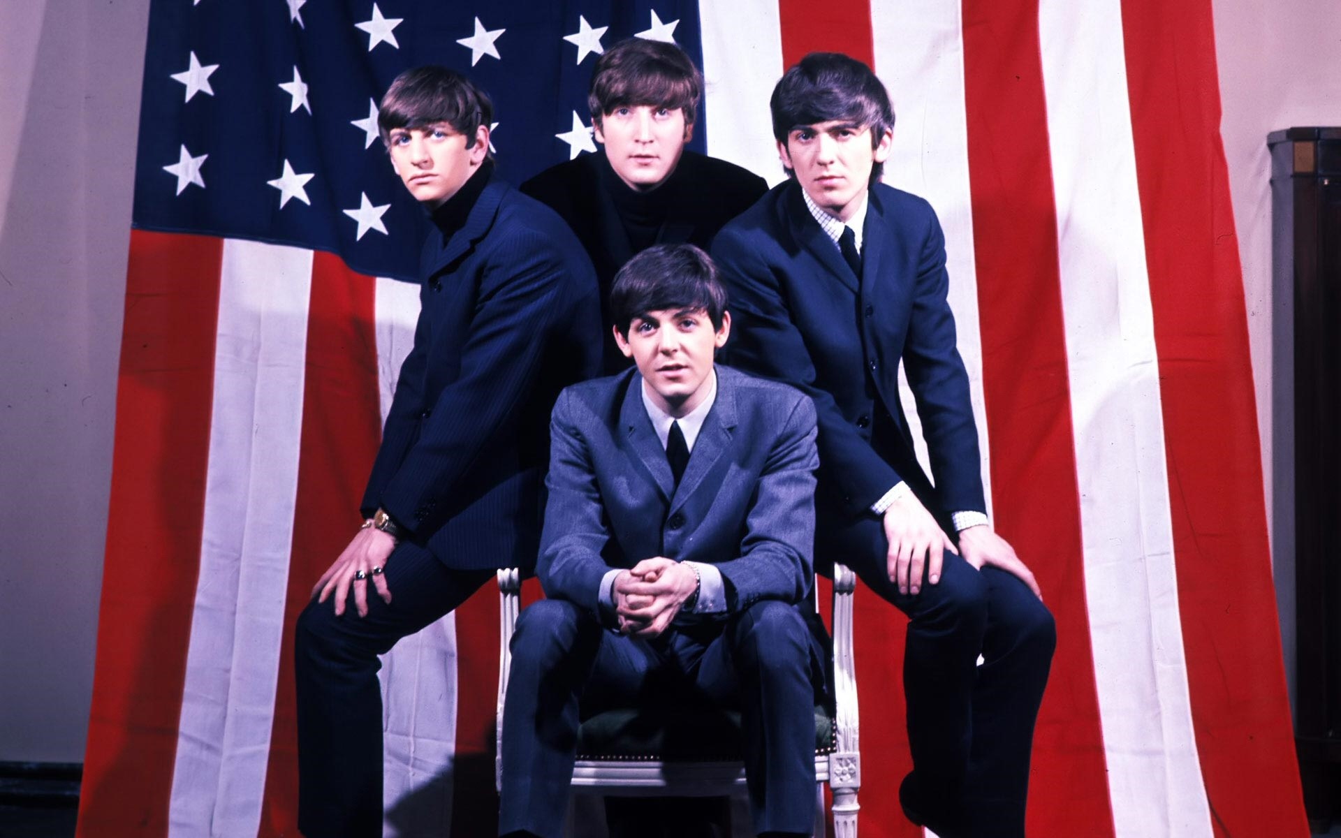 The Beatles posing in front of an American flag HD Wallpaper