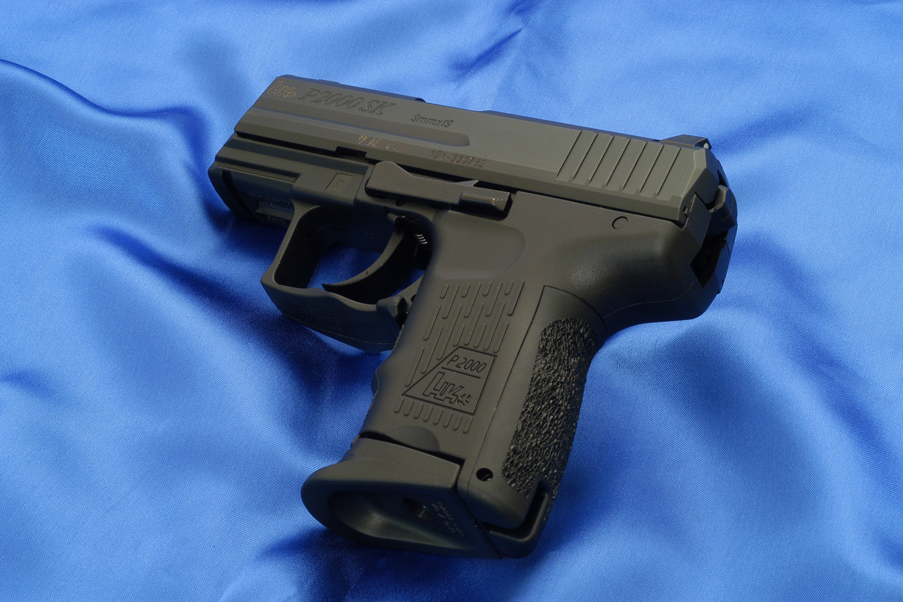 Heckler & Koch P2000 SK pistol on blue fabric HD Wallpaper