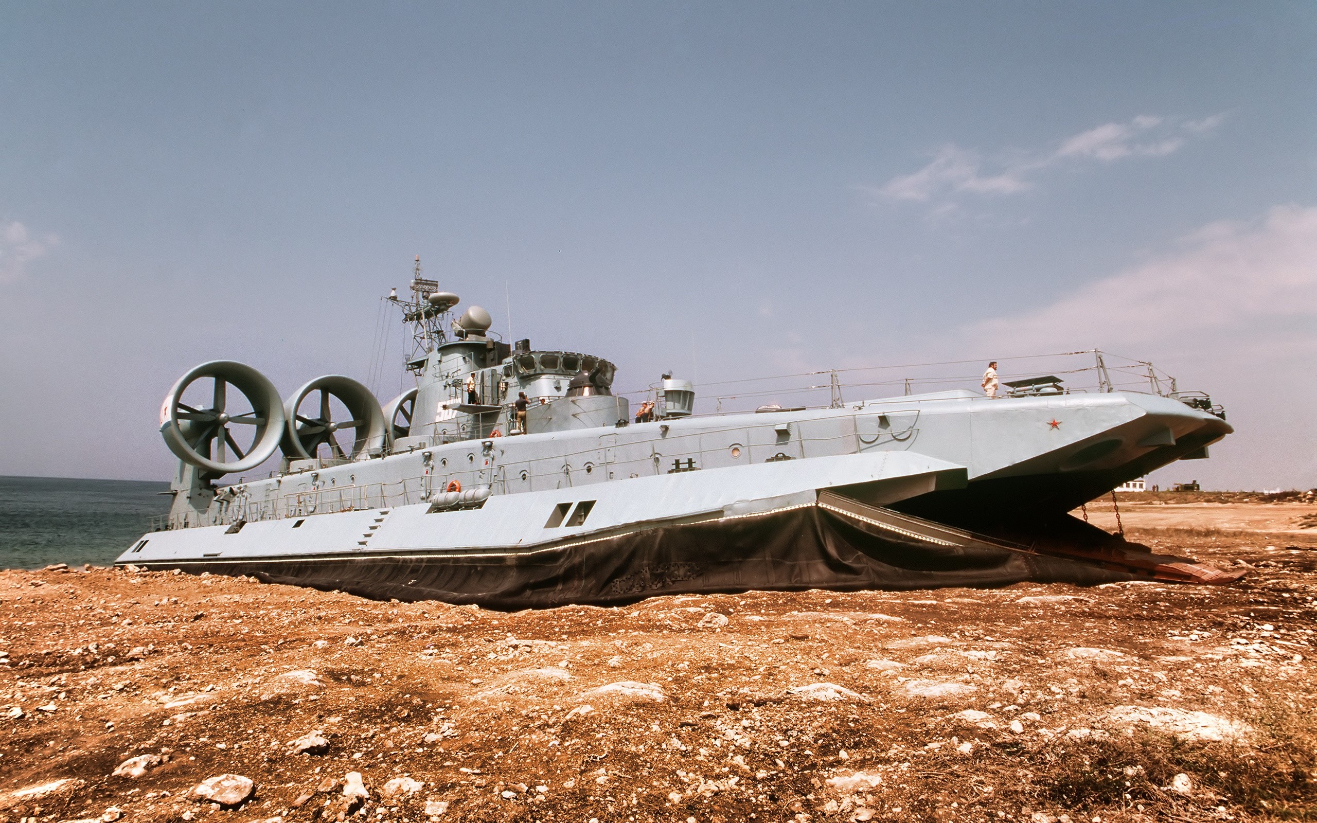 Large hovercraft beached on a rocky shore HD Wallpaper