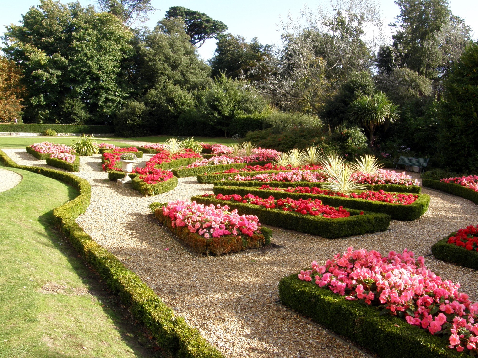 Formal garden with manicured hedges and flower beds HD Wallpaper