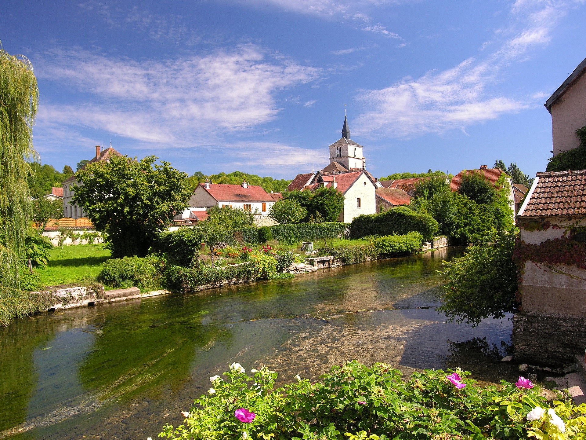 River flowing through a French village with a church HD Wallpaper