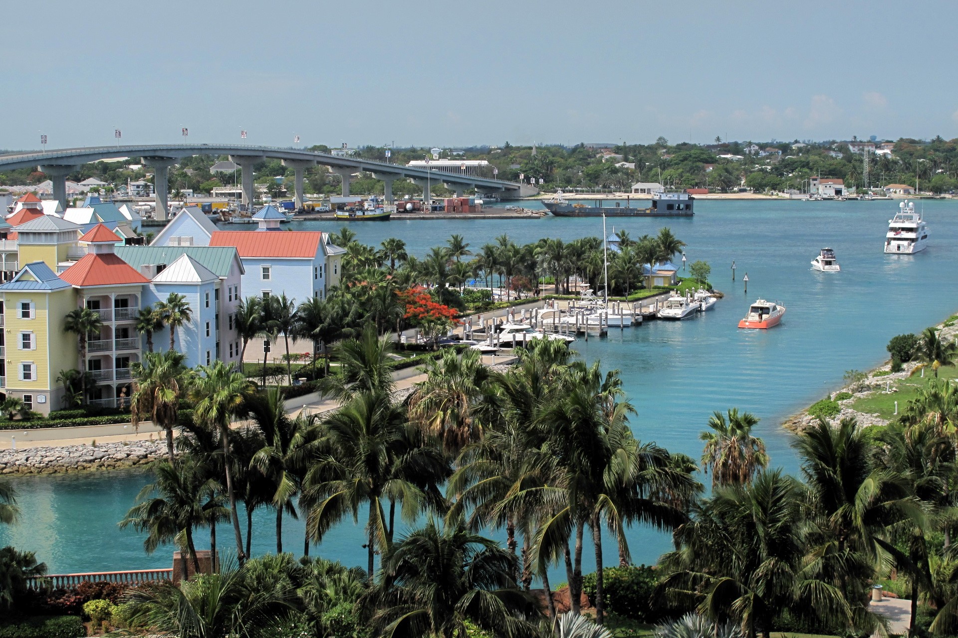 Colorful buildings and yachts in a tropical harbor with a bridge HD Wallpaper