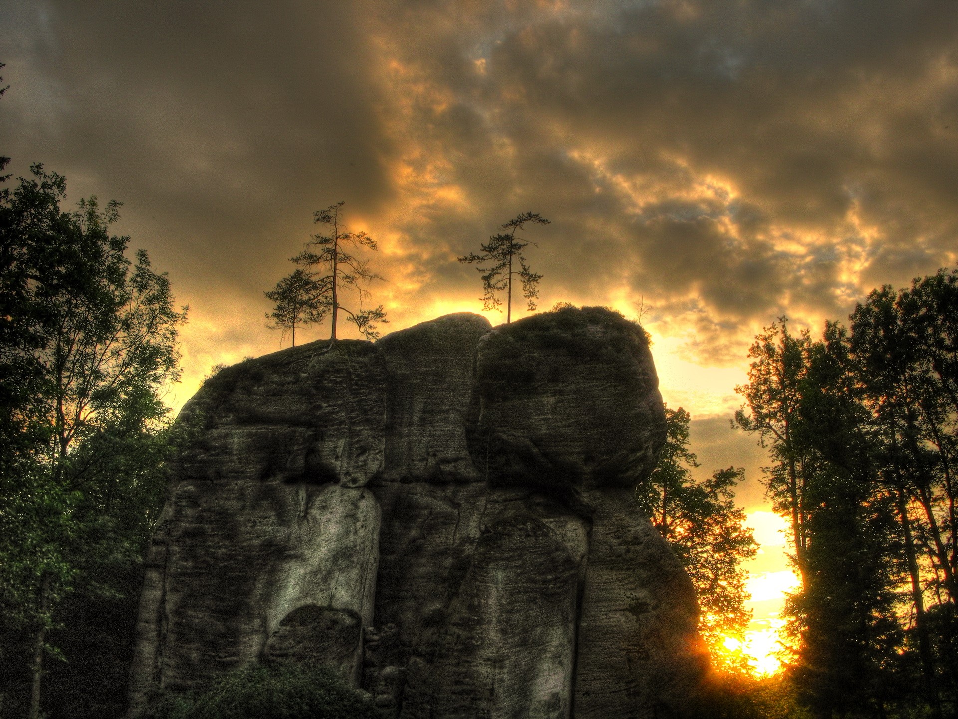 Rocky outcrop with trees at sunset HD Wallpaper