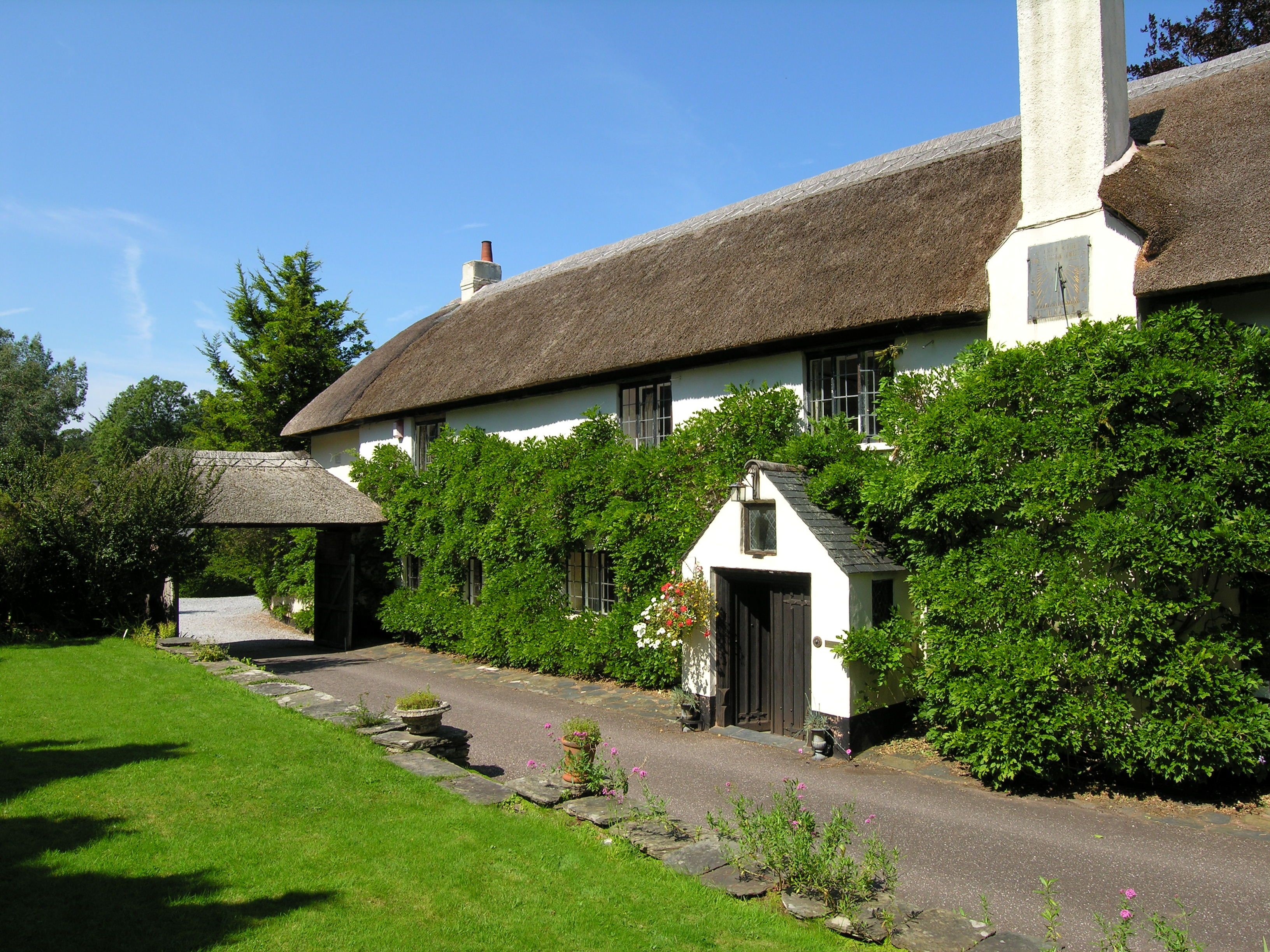 Thatched cottage with ivy and a covered walkway in the UK HD Wallpaper
