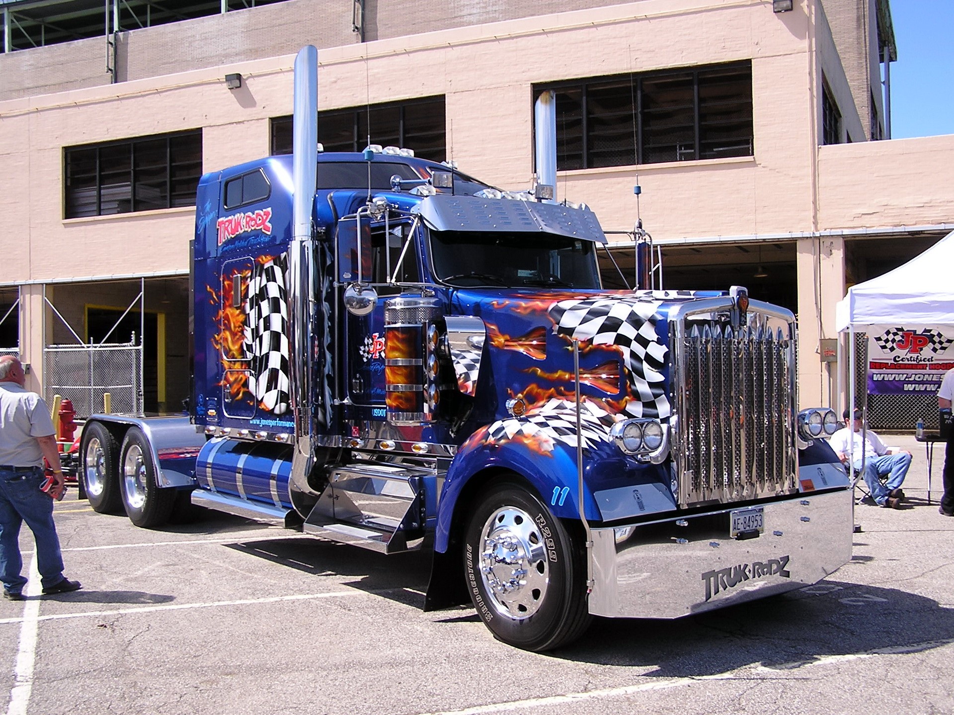Customized blue semi-truck with flames and checkered flags HD Wallpaper