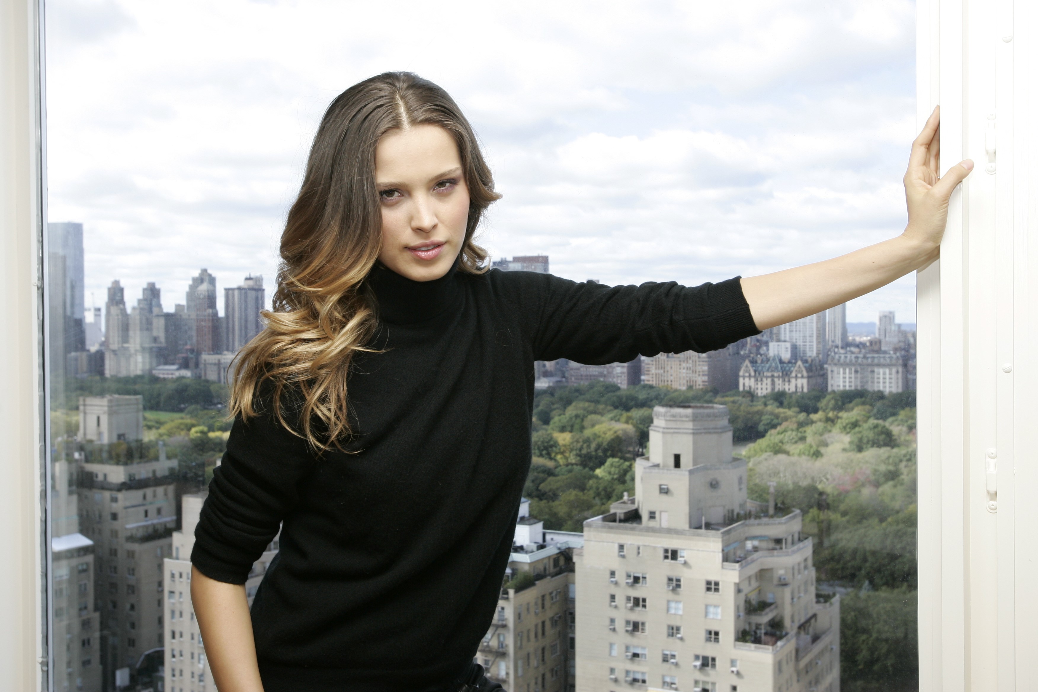 Petra Nemcova posing by a window overlooking a city HD Wallpaper