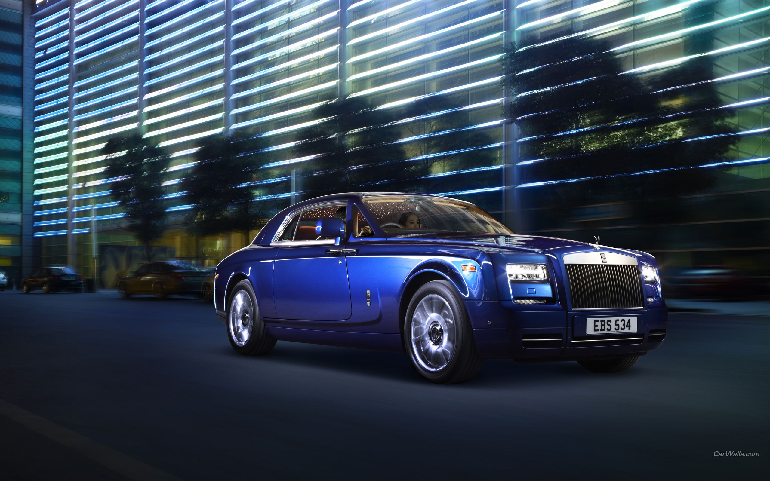 Blue Rolls-Royce Coupe driving on a city street at night HD Wallpaper