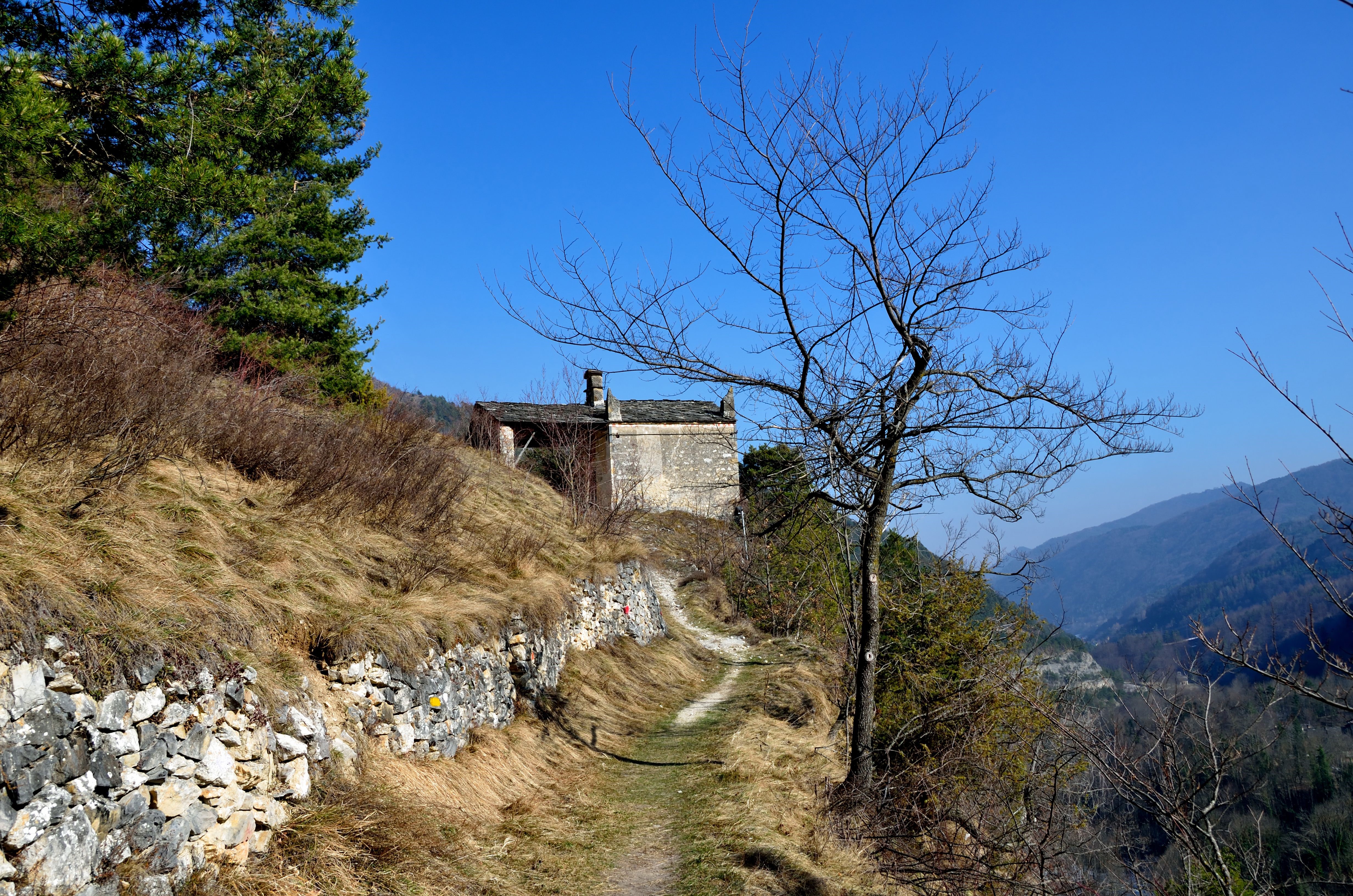Stone building on a hillside path in Italy HD Wallpaper