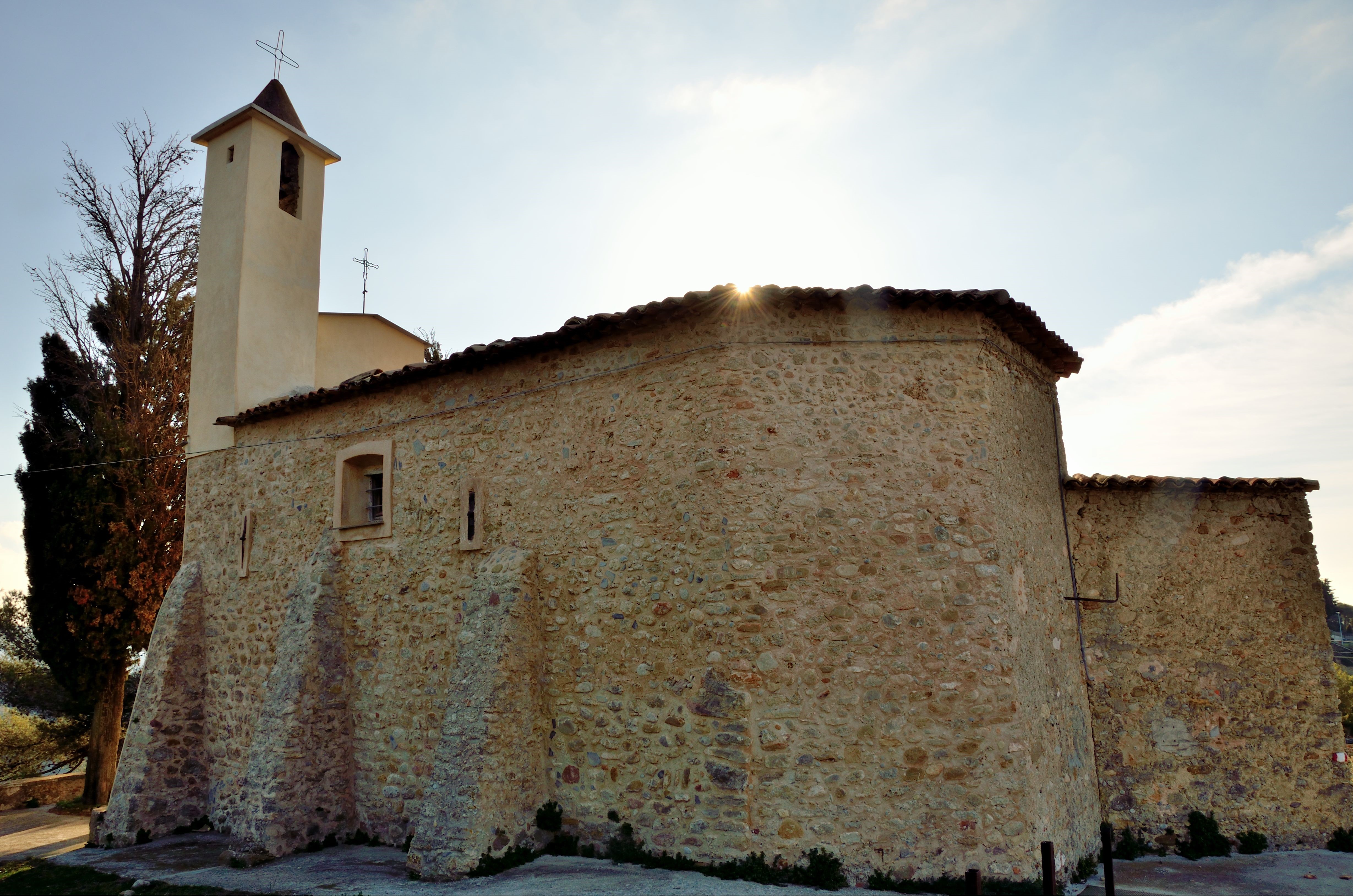 Stone church with bell tower and sun rays HD Wallpaper