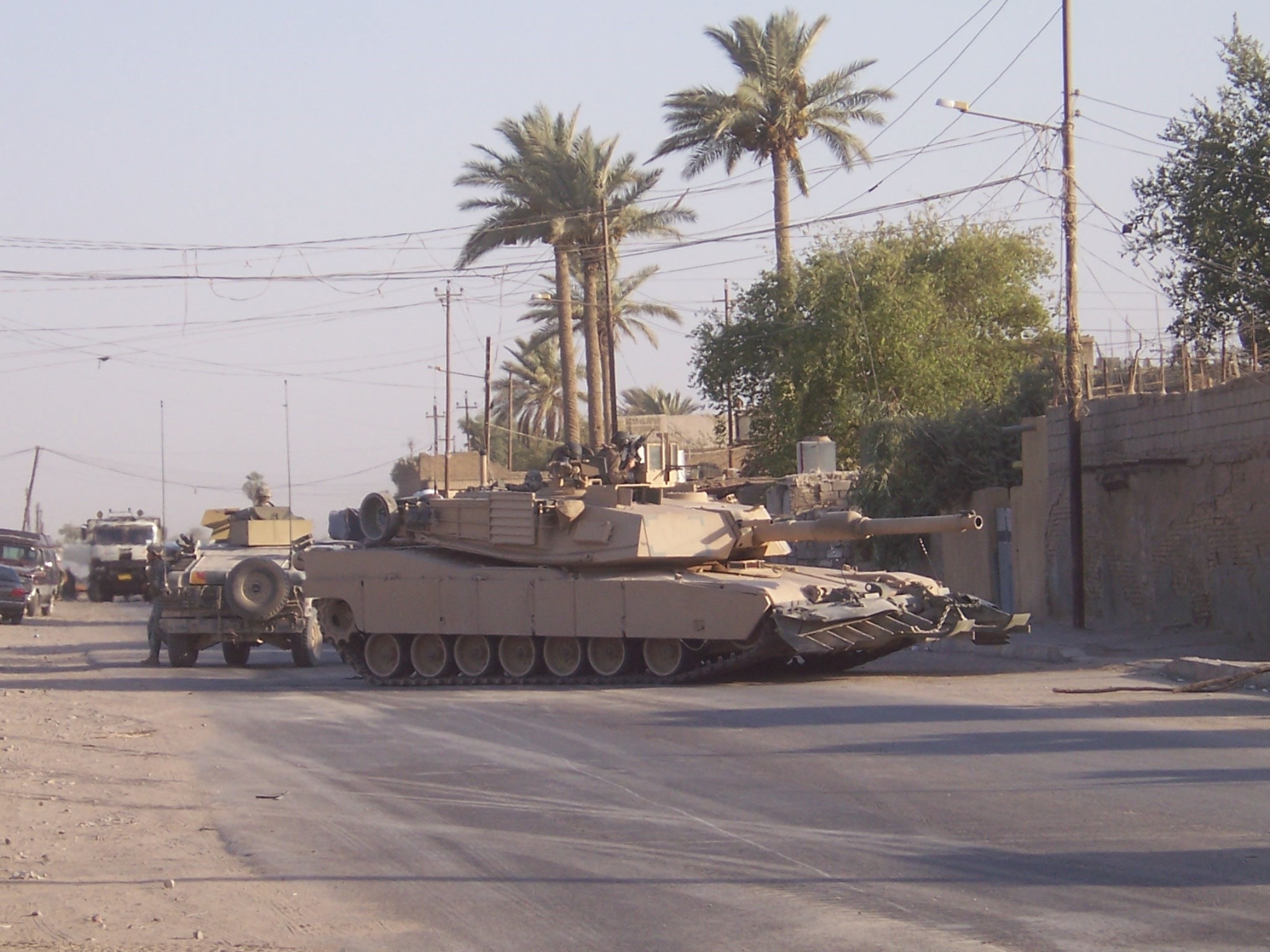 M1 Abrams tank on a street with palm trees HD Wallpaper