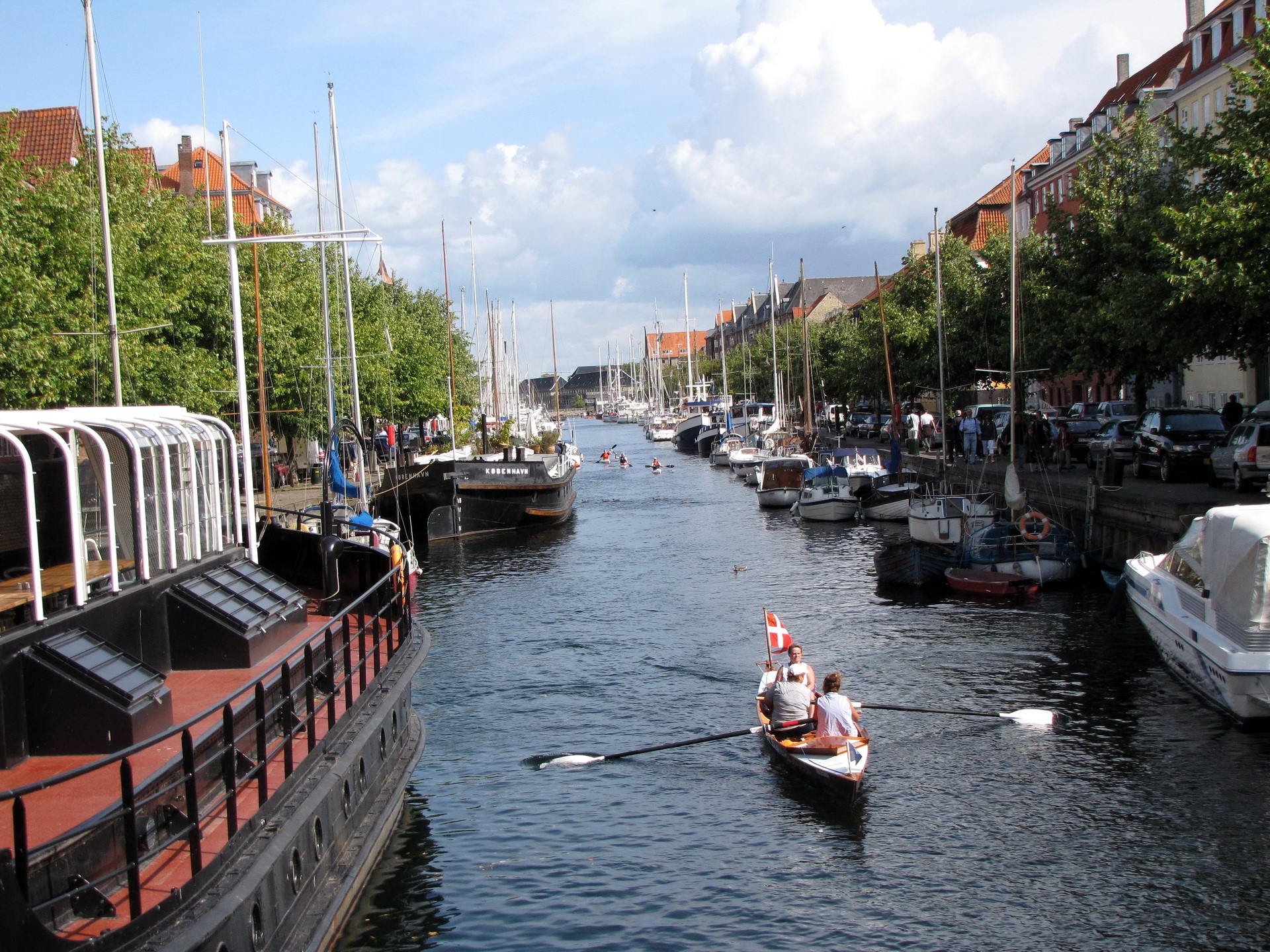 Canal in Copenhagen, Denmark with boats and people rowing HD Wallpaper