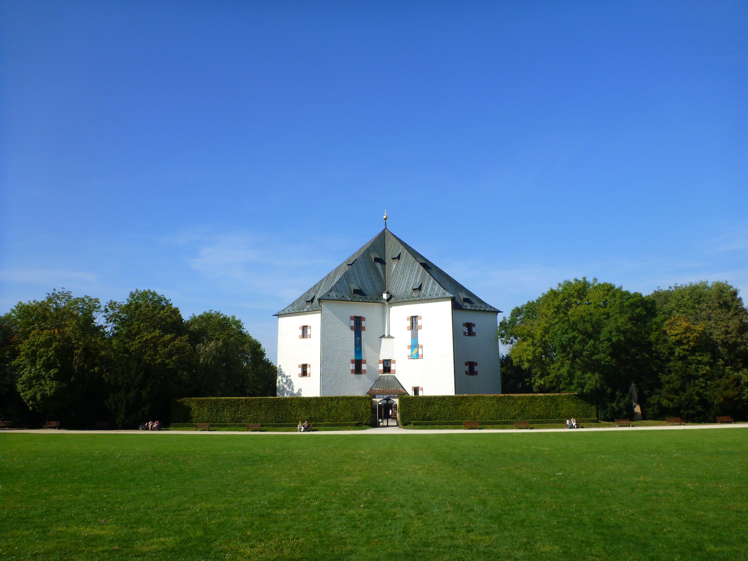 White building with a dark roof in a park HD Wallpaper
