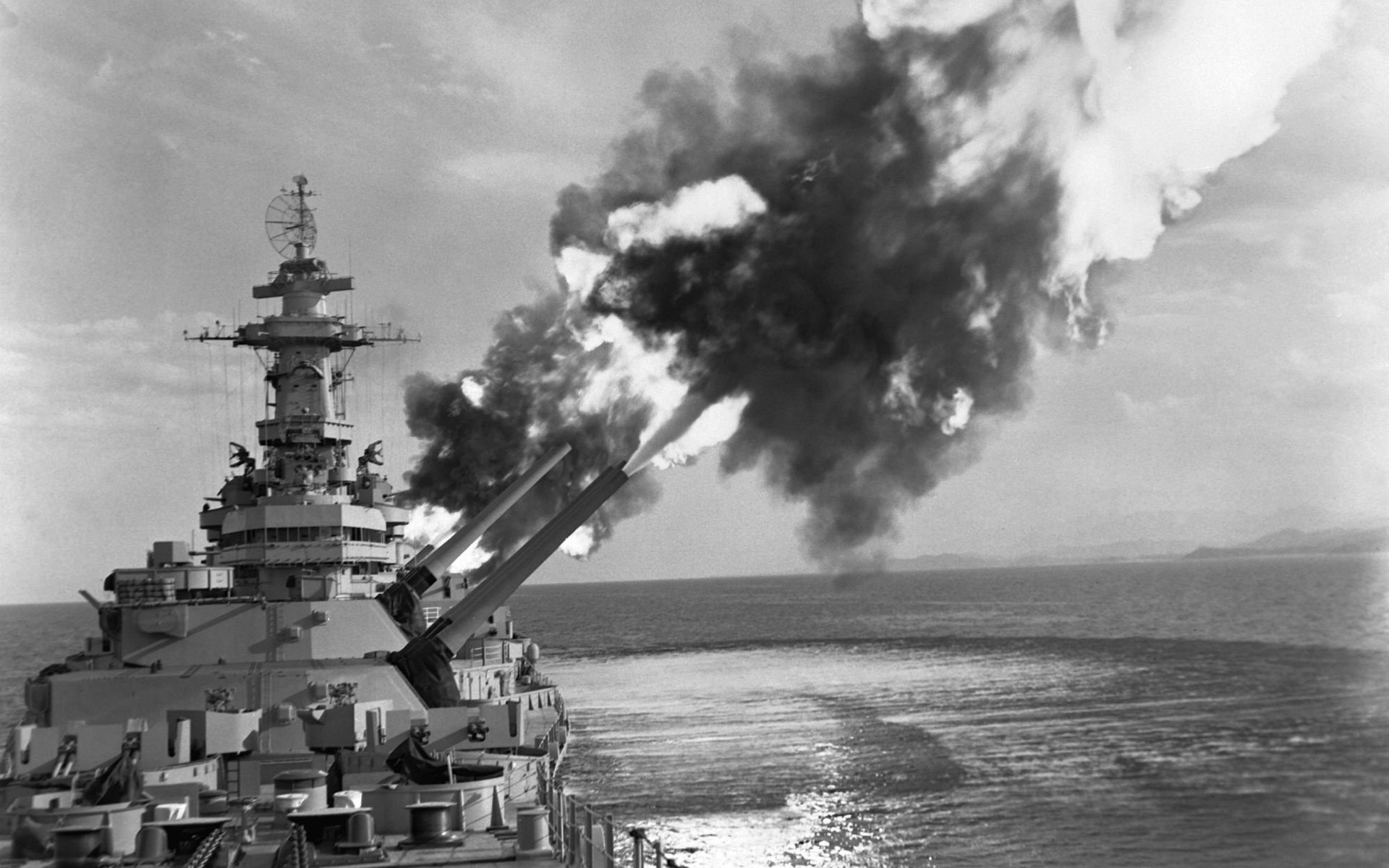 Battleship firing its main guns at sea HD Wallpaper