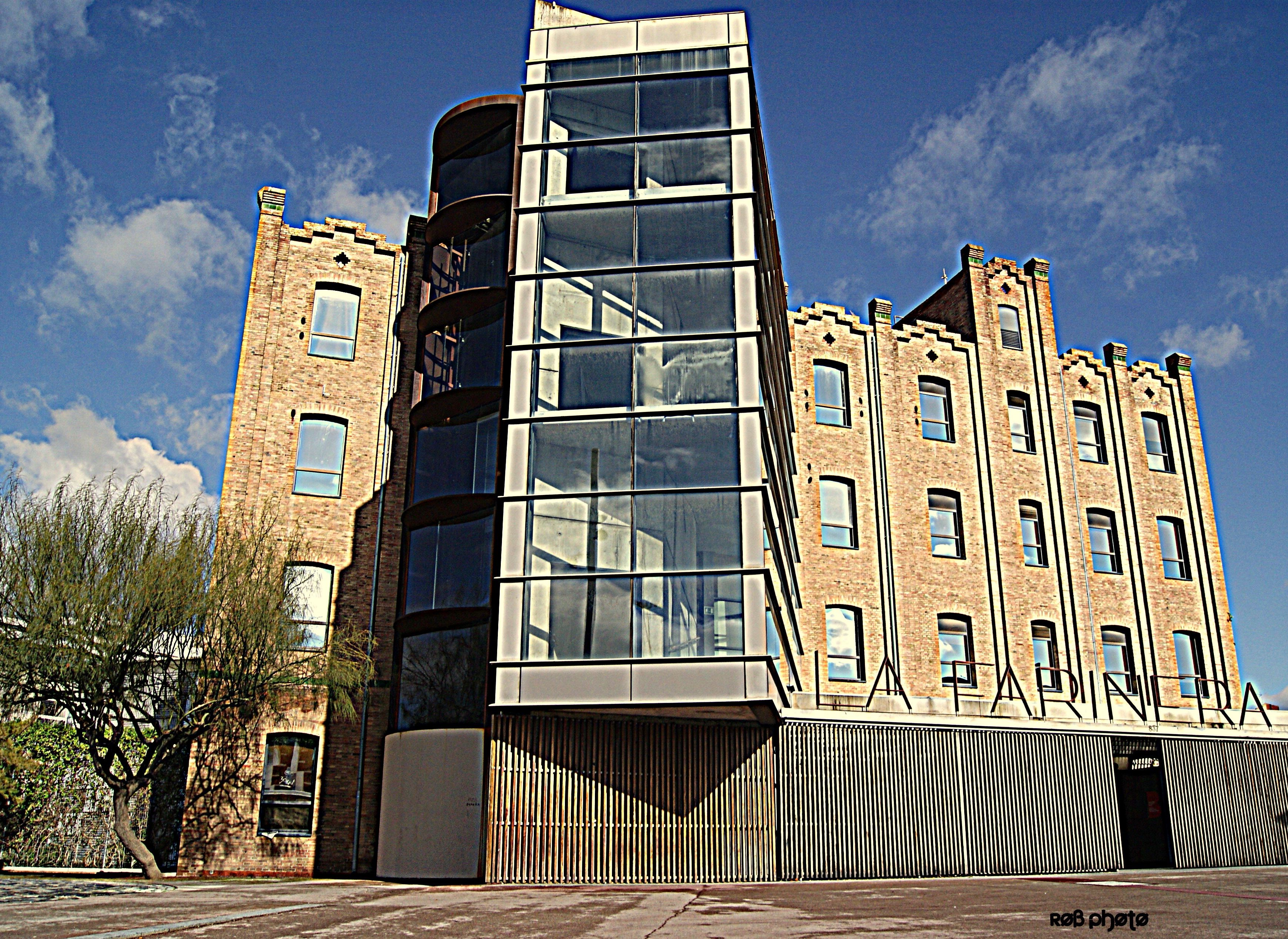 Modern glass building attached to old brick factory HD Wallpaper