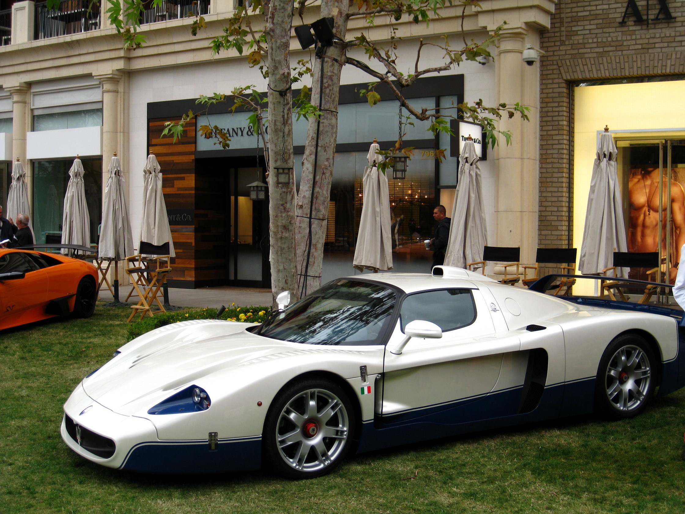 Maserati MC12 parked on grass in front of Tiffany & Co. HD Wallpaper