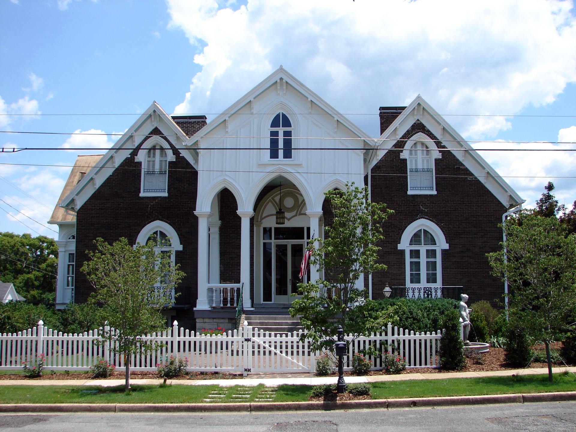 Gothic Revival house with white picket fence HD Wallpaper
