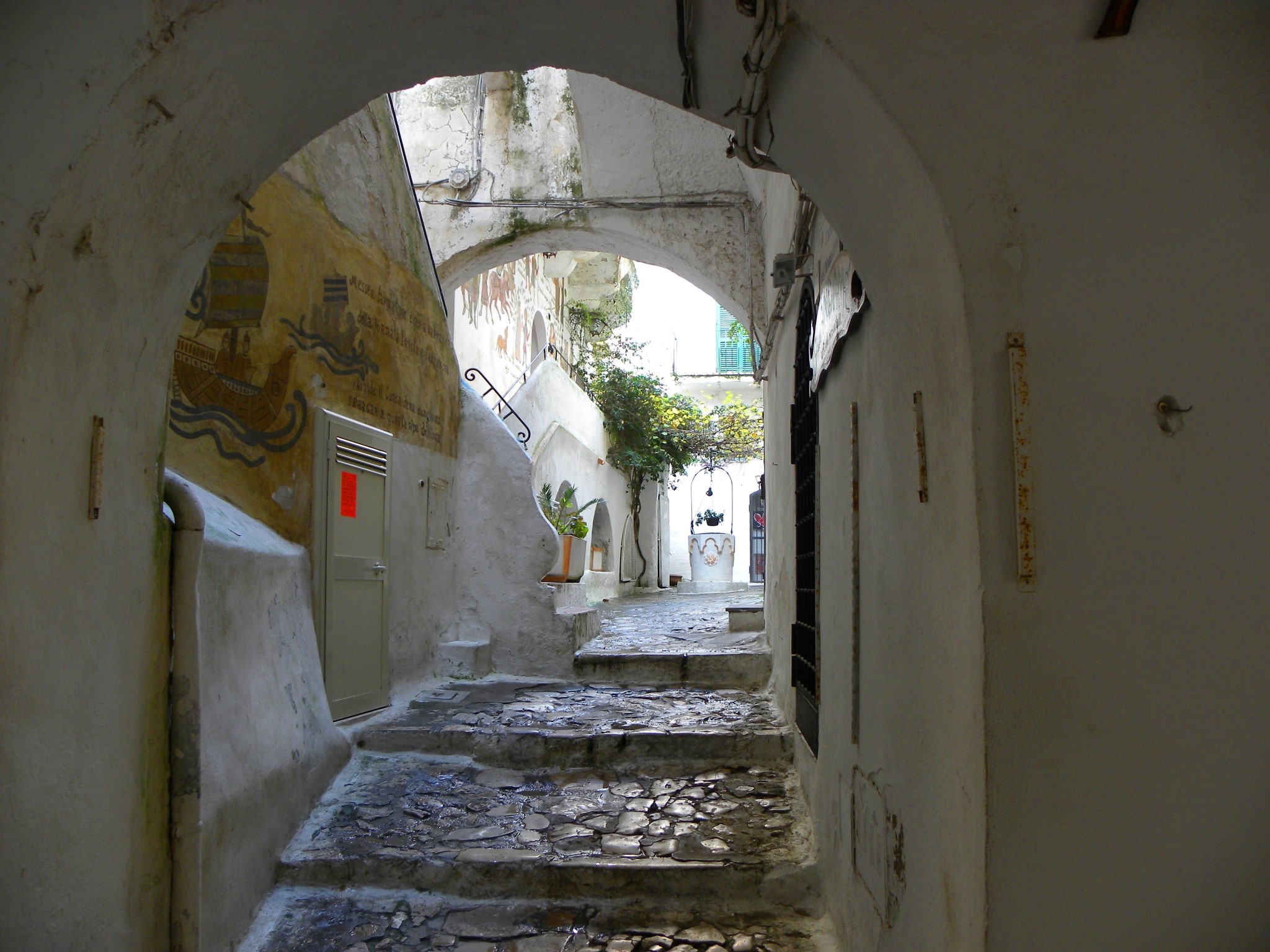 Narrow alleyway with stone steps and murals in Sperlonga, Italy HD Wallpaper