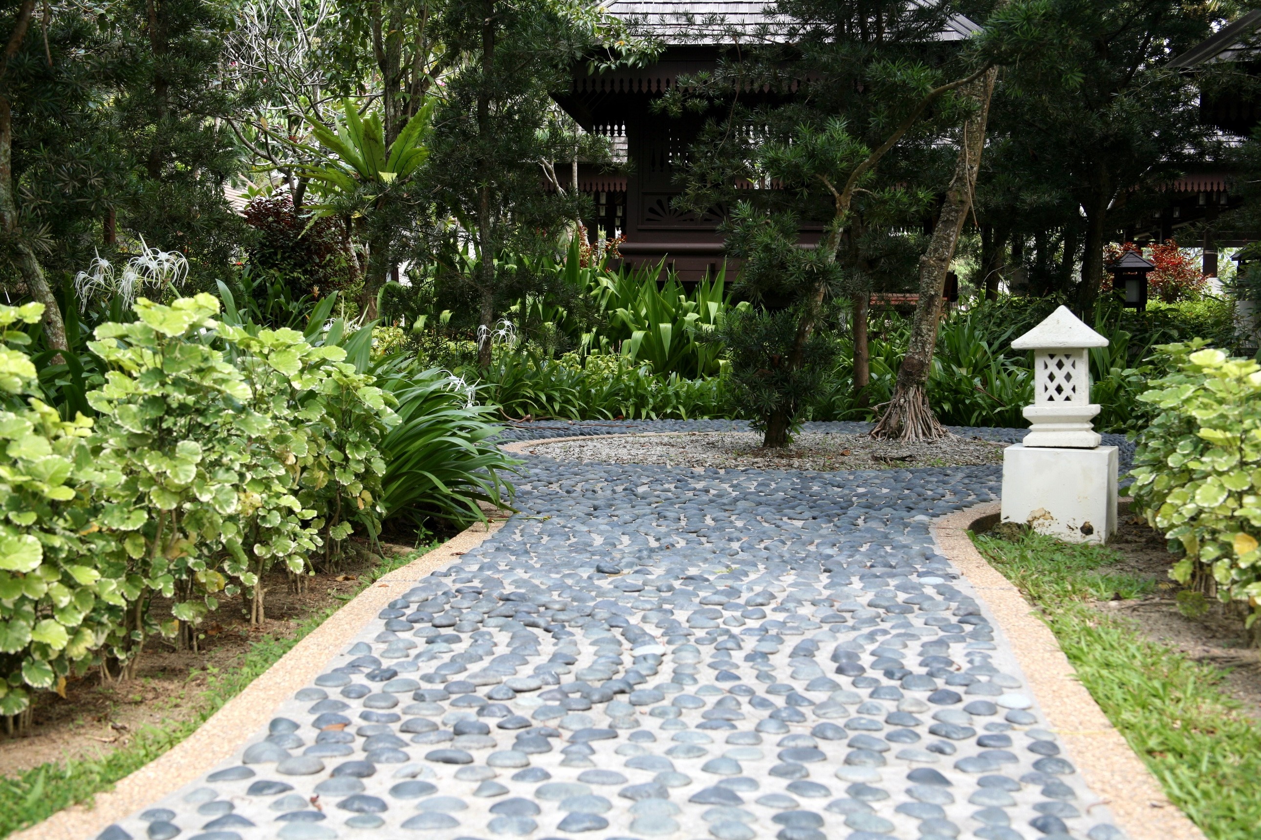 Stone pathway in a lush garden with a pagoda HD Wallpaper