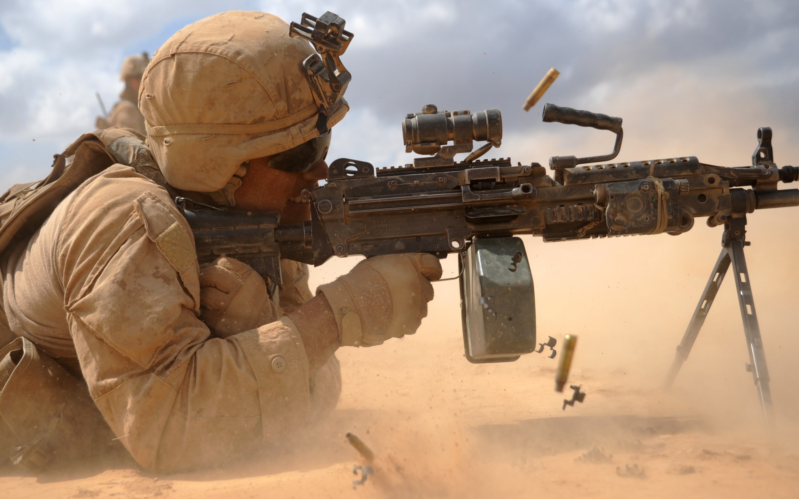 Soldier firing a machine gun in the desert HD Wallpaper
