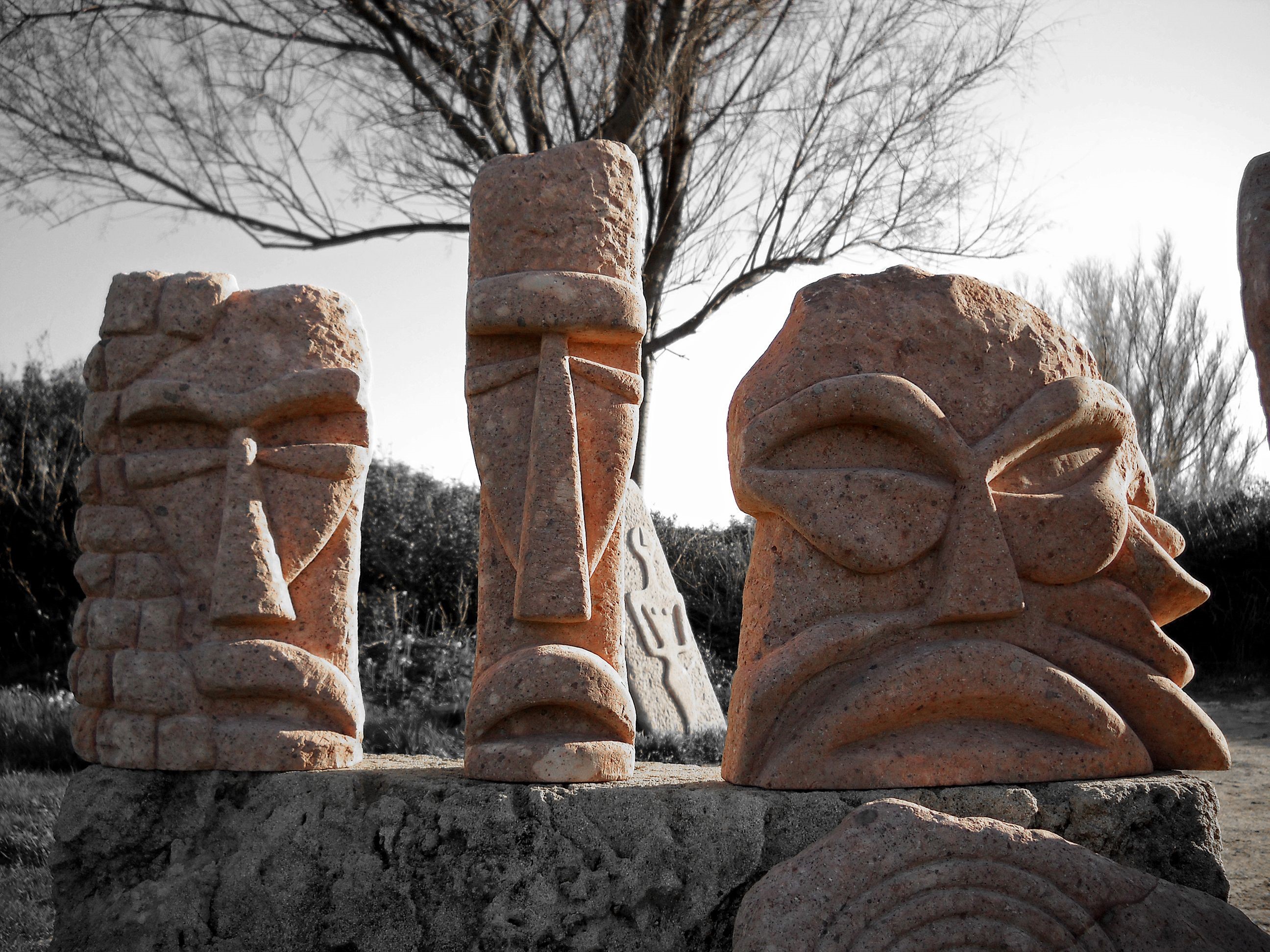Stone sculptures of faces in a park HD Wallpaper