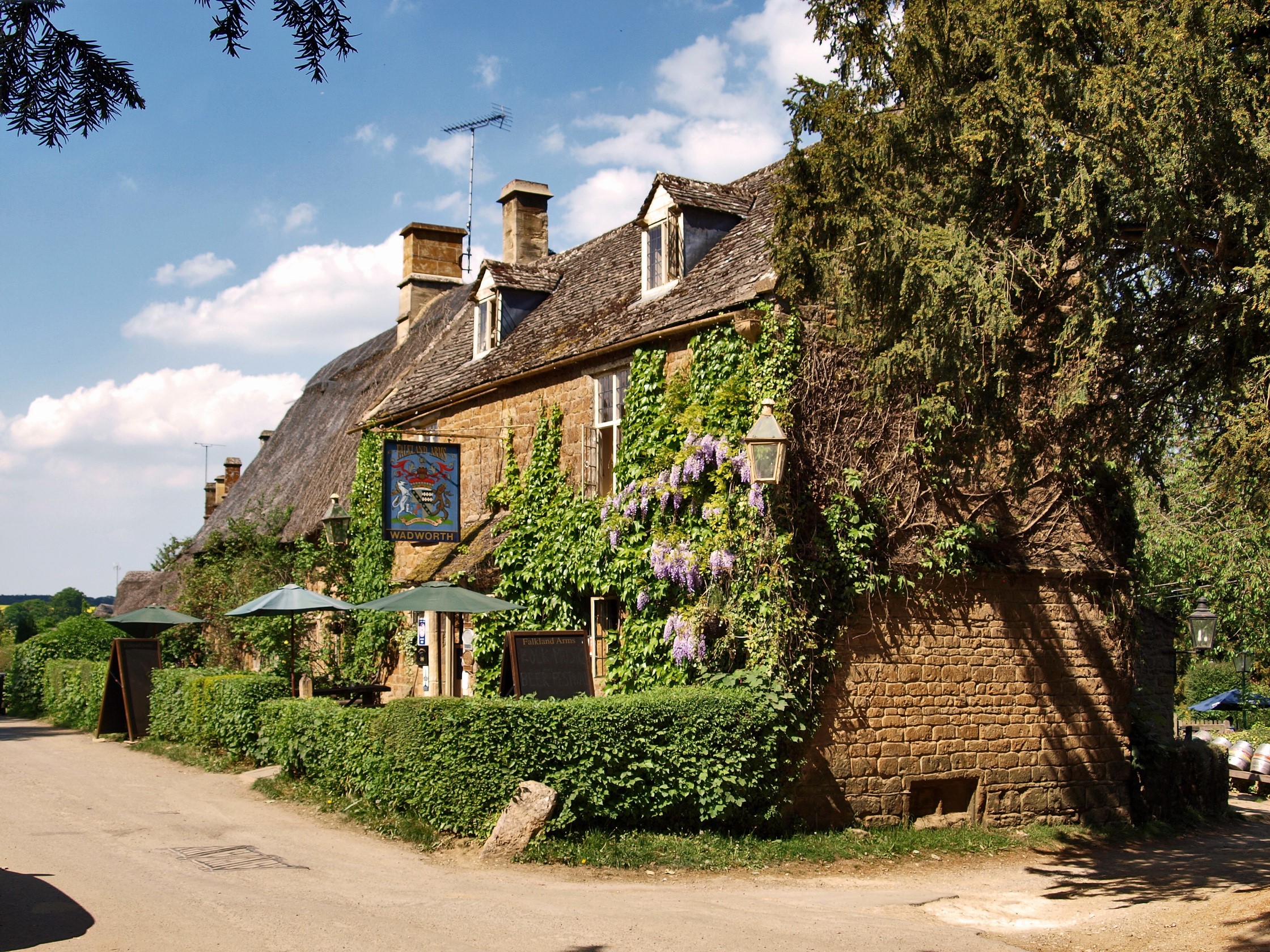 Thatched roof pub with ivy and wisteria HD Wallpaper