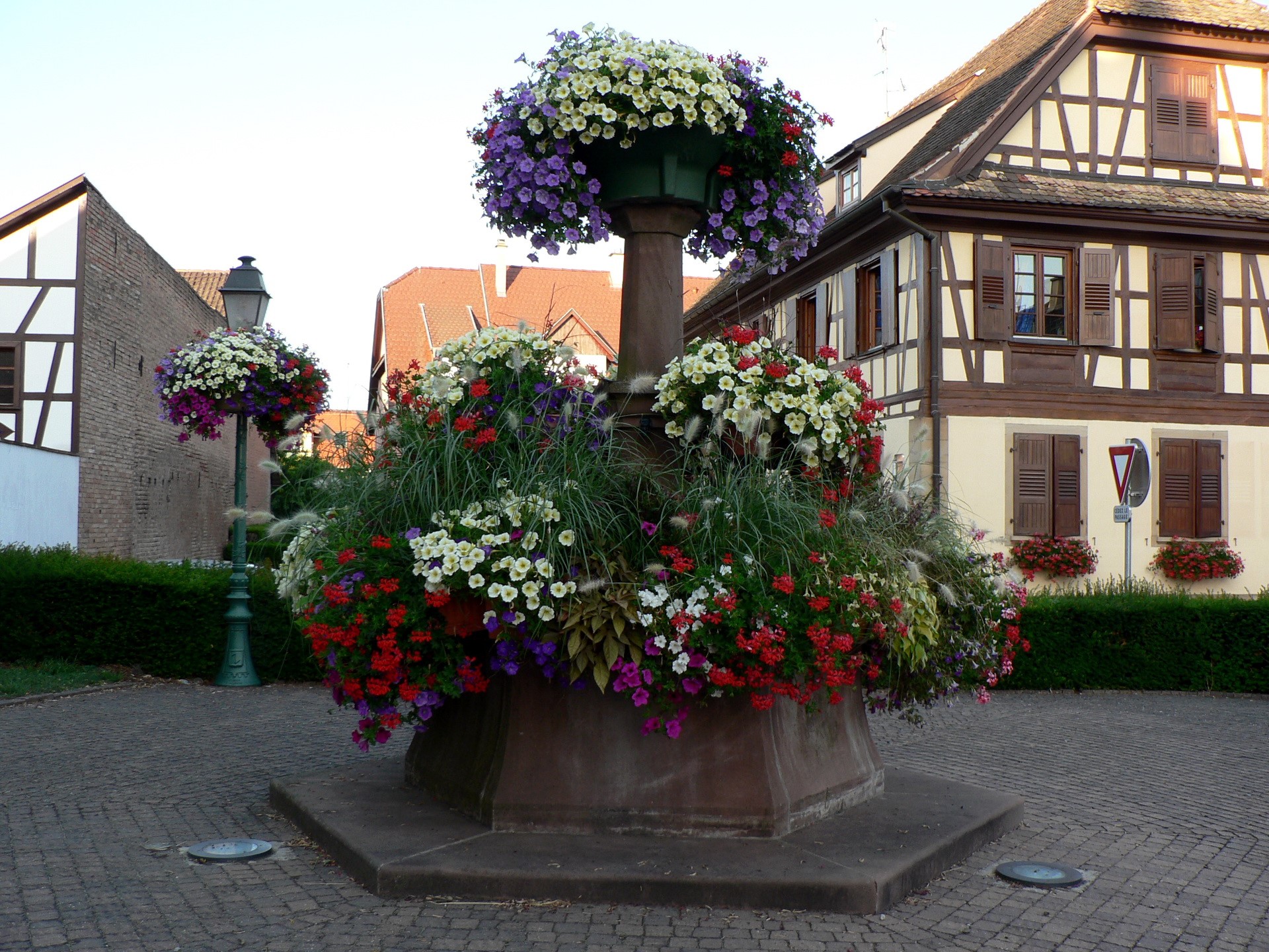 Flower fountain and half-timbered houses in France HD Wallpaper